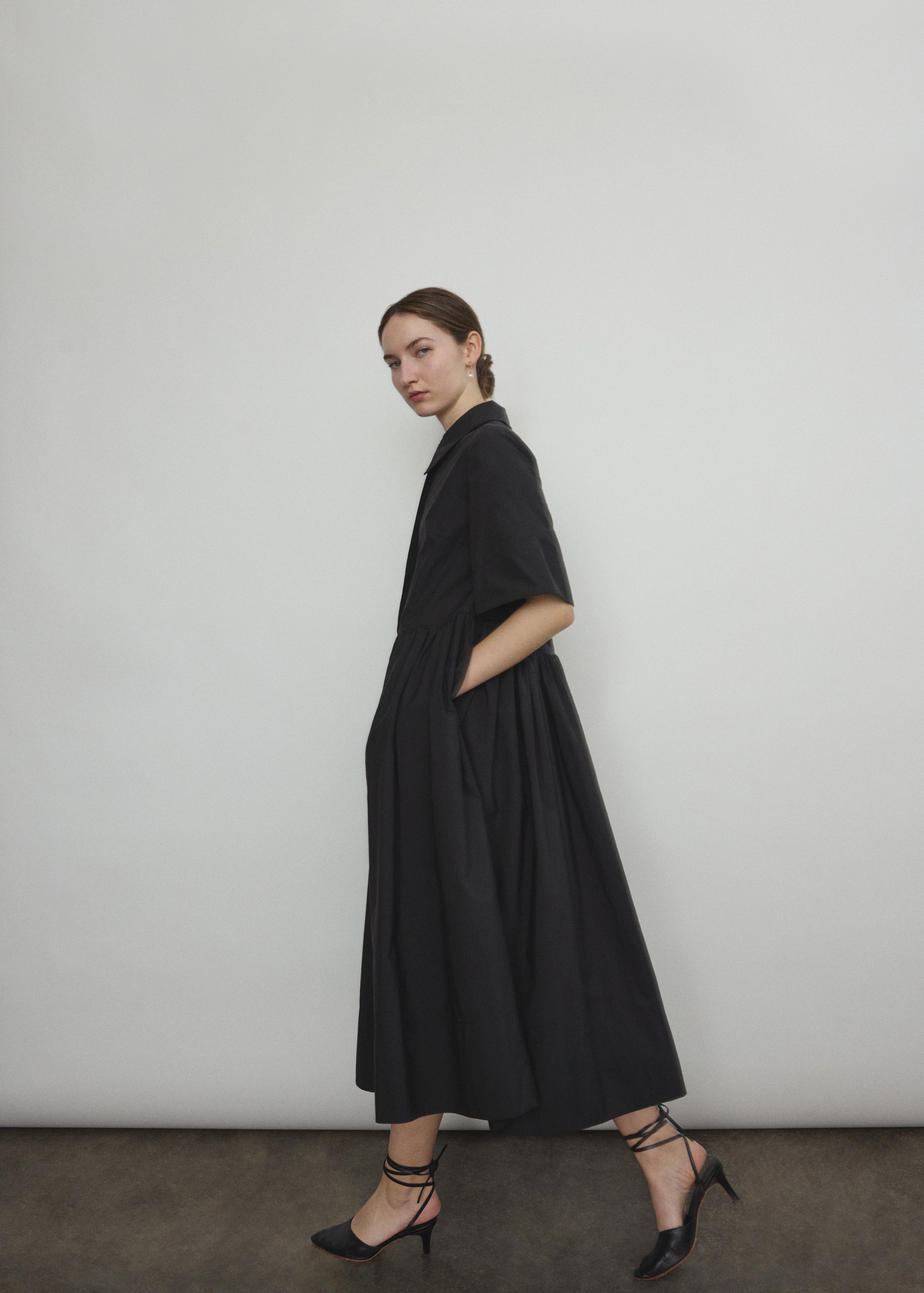 Angled view of the black Japanese cotton lawn Kamperett Miller Dress with hidden placket button front.