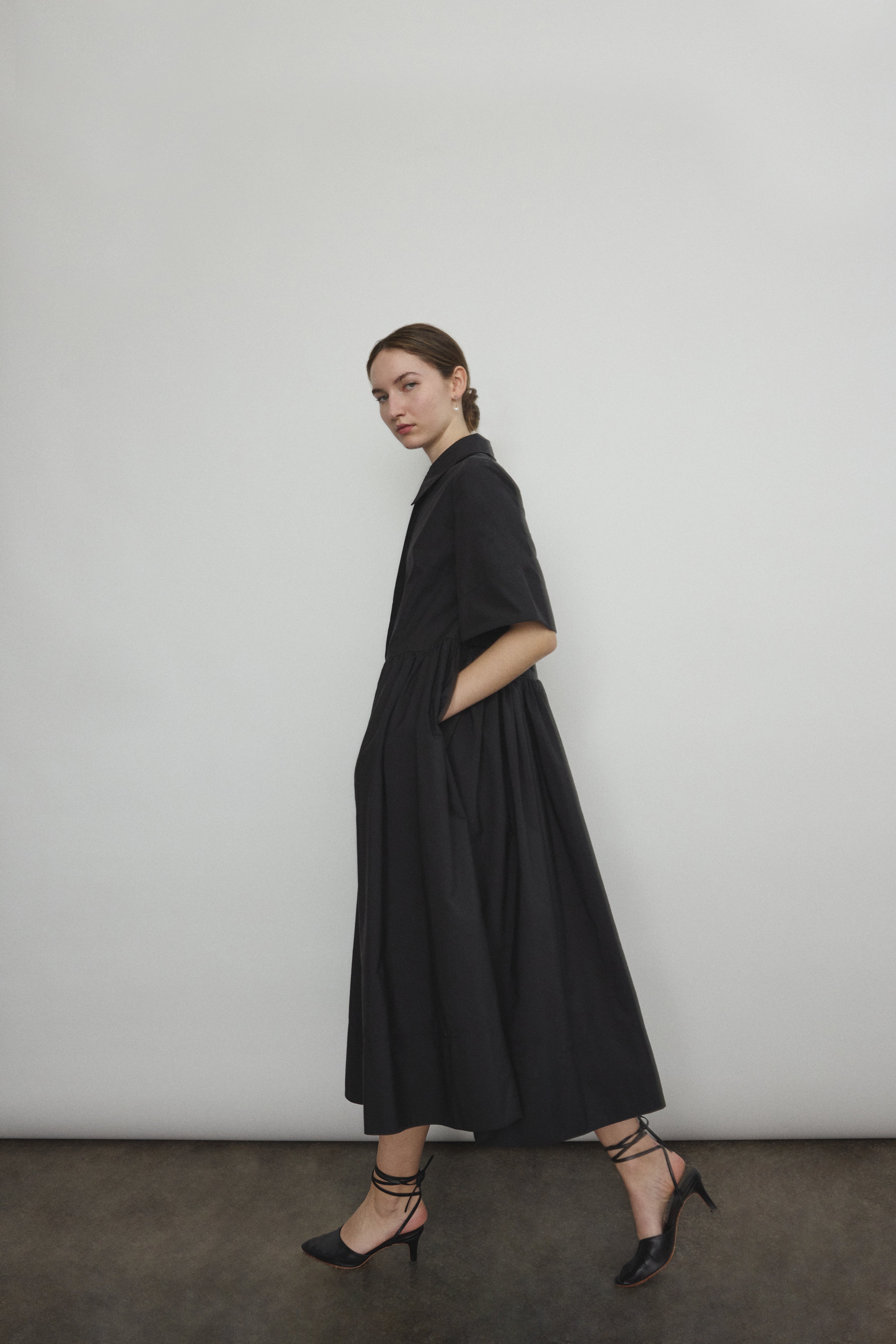 Angled view of the black Japanese cotton lawn Kamperett Miller Dress with hidden placket button front.
