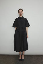 Front view of a model wearing the black Japanese cotton lawn Kamperett Miller Dress, an oversized shirt dress with button front.