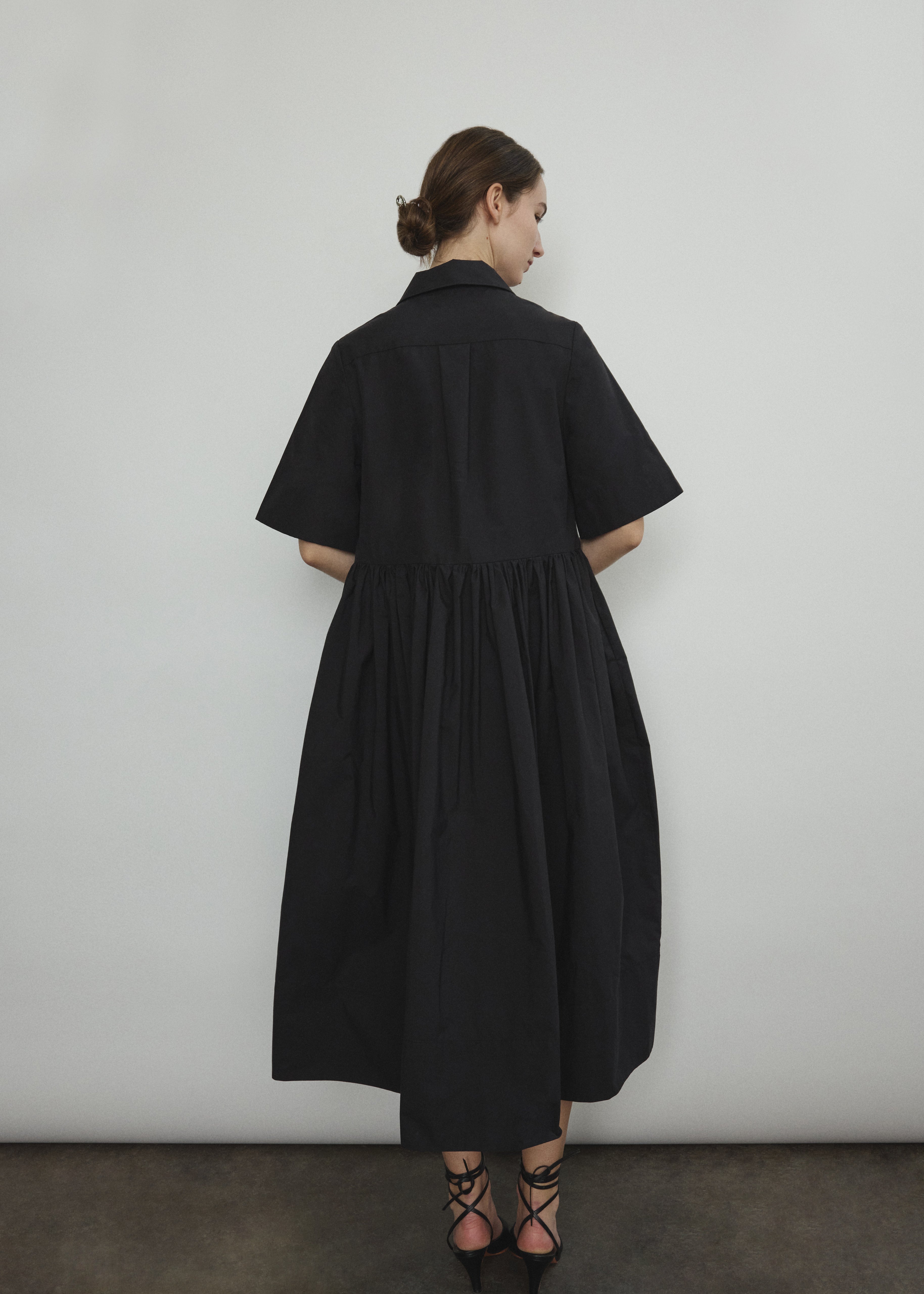 Side view of the black Japanese cotton lawn Kamperett Miller Dress with gathered waist and short sleeves.