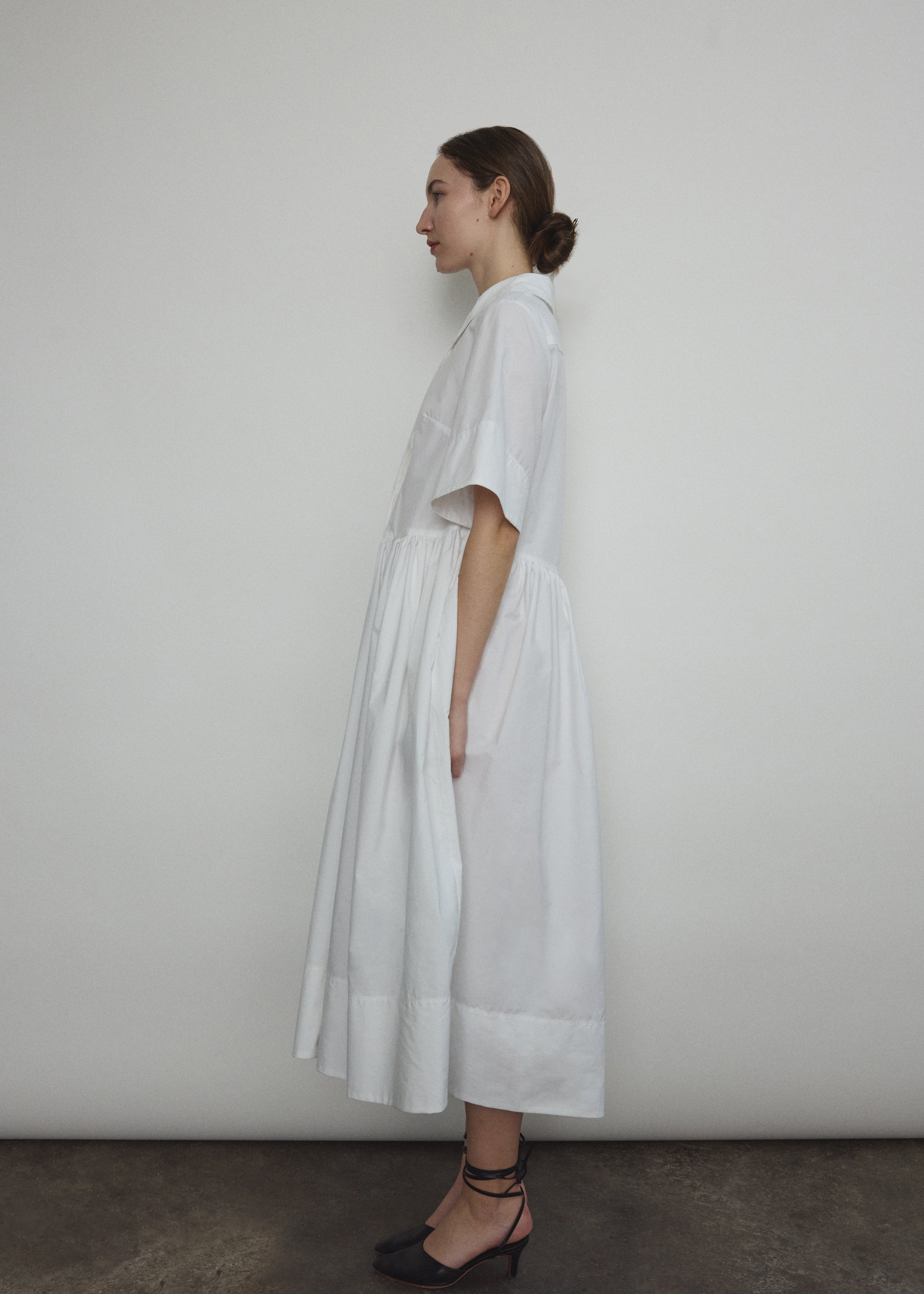 Angled view of the white Japanese cotton lawn Kamperett Miller Dress with hidden placket button front.