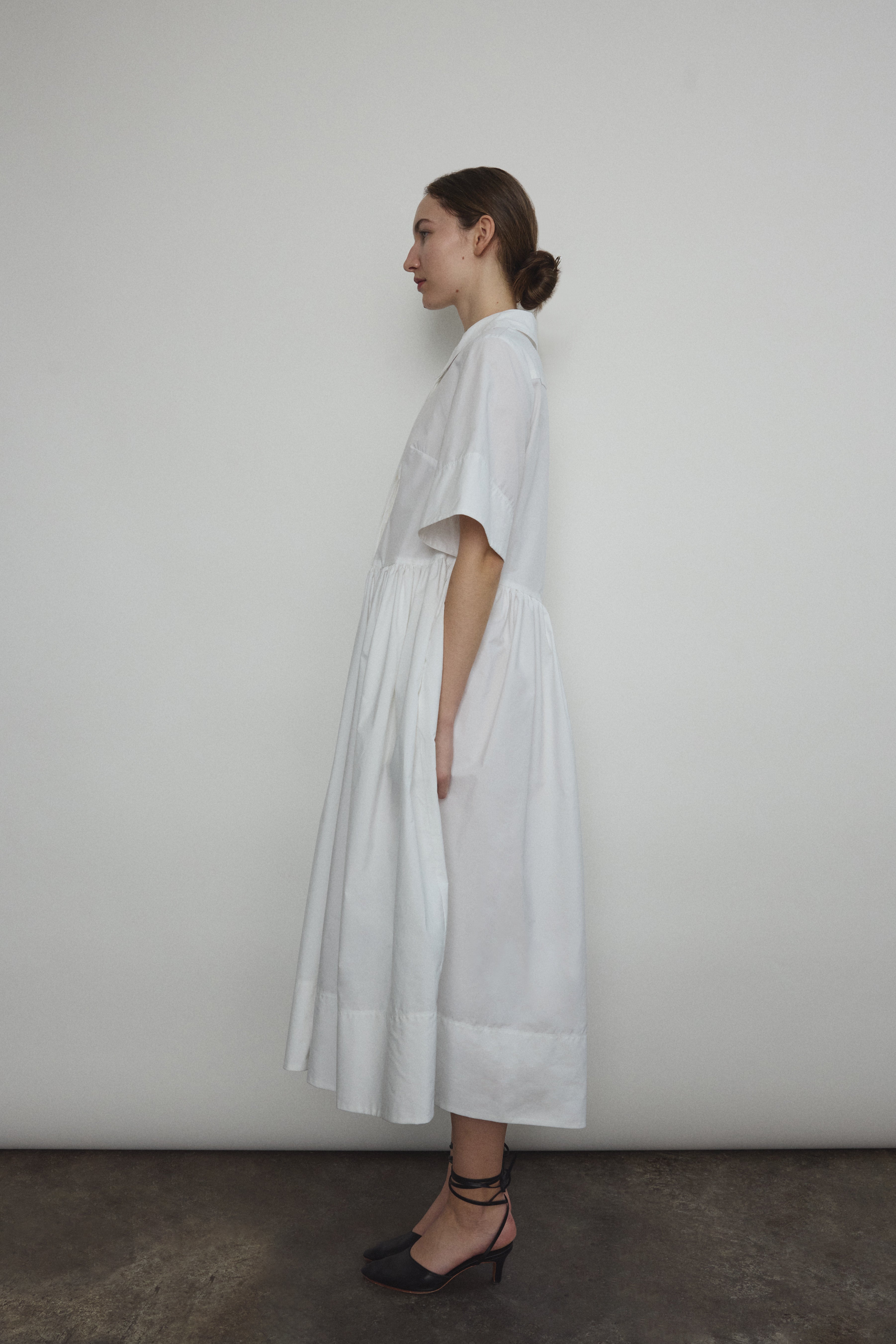 Angled view of the white Japanese cotton lawn Kamperett Miller Dress with hidden placket button front.