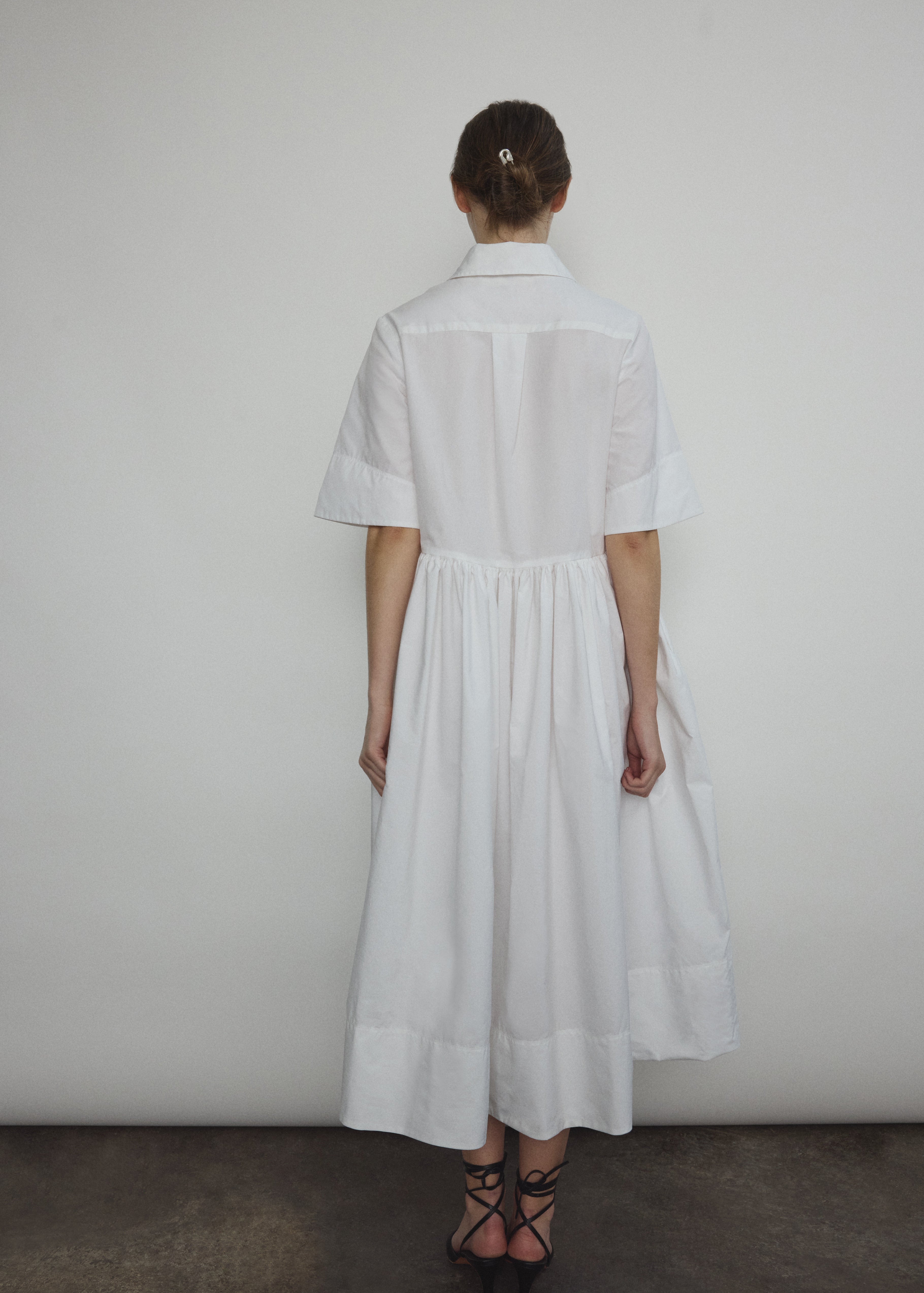 Side view of the white Japanese cotton lawn Kamperett Miller Dress with gathered waist and short sleeves.