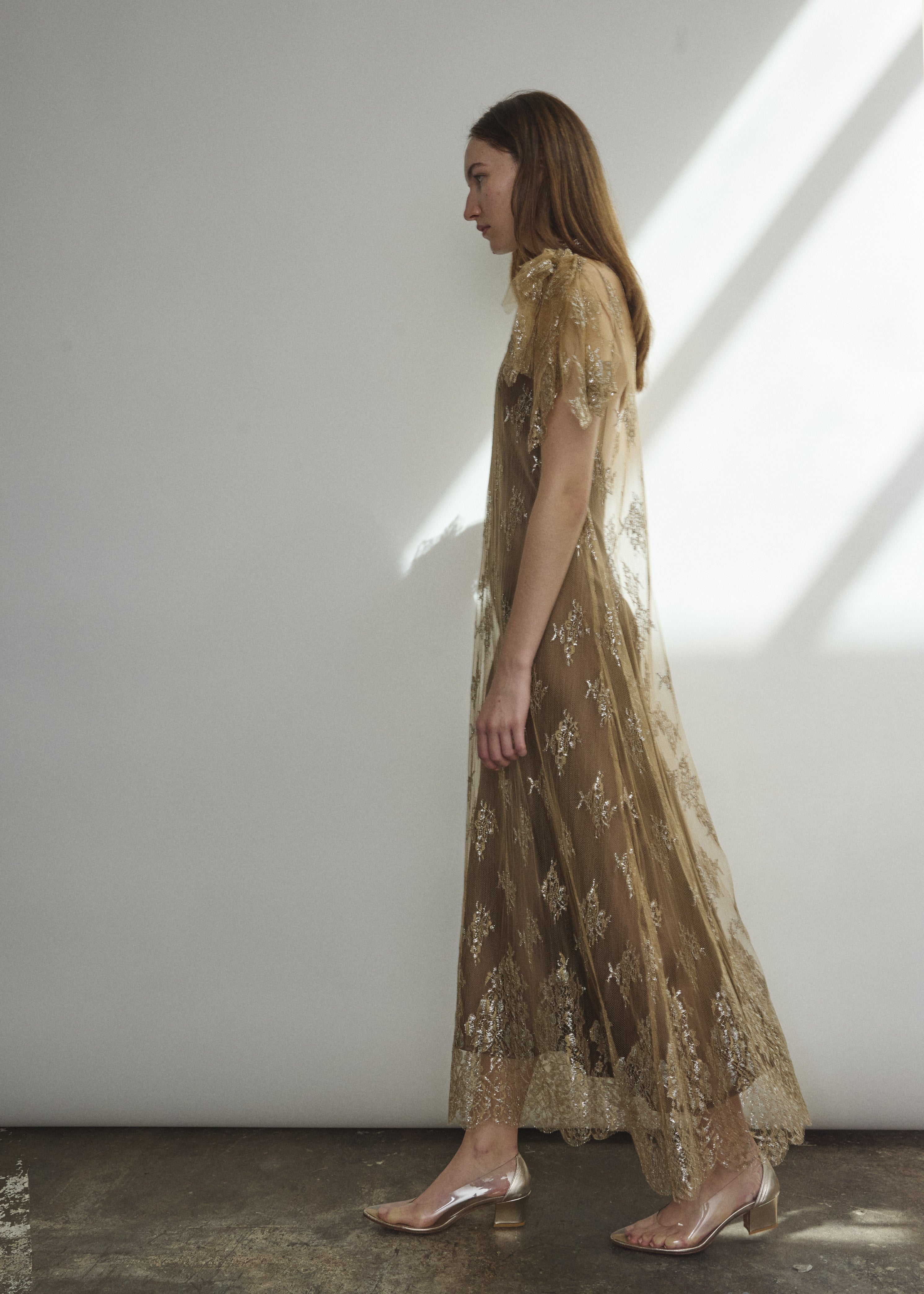 Left profile of Kamperett Moony Lace Gown in mink French lace, straight sheath silhouette with deconstructed cap sleeve and soft metallic detailing.