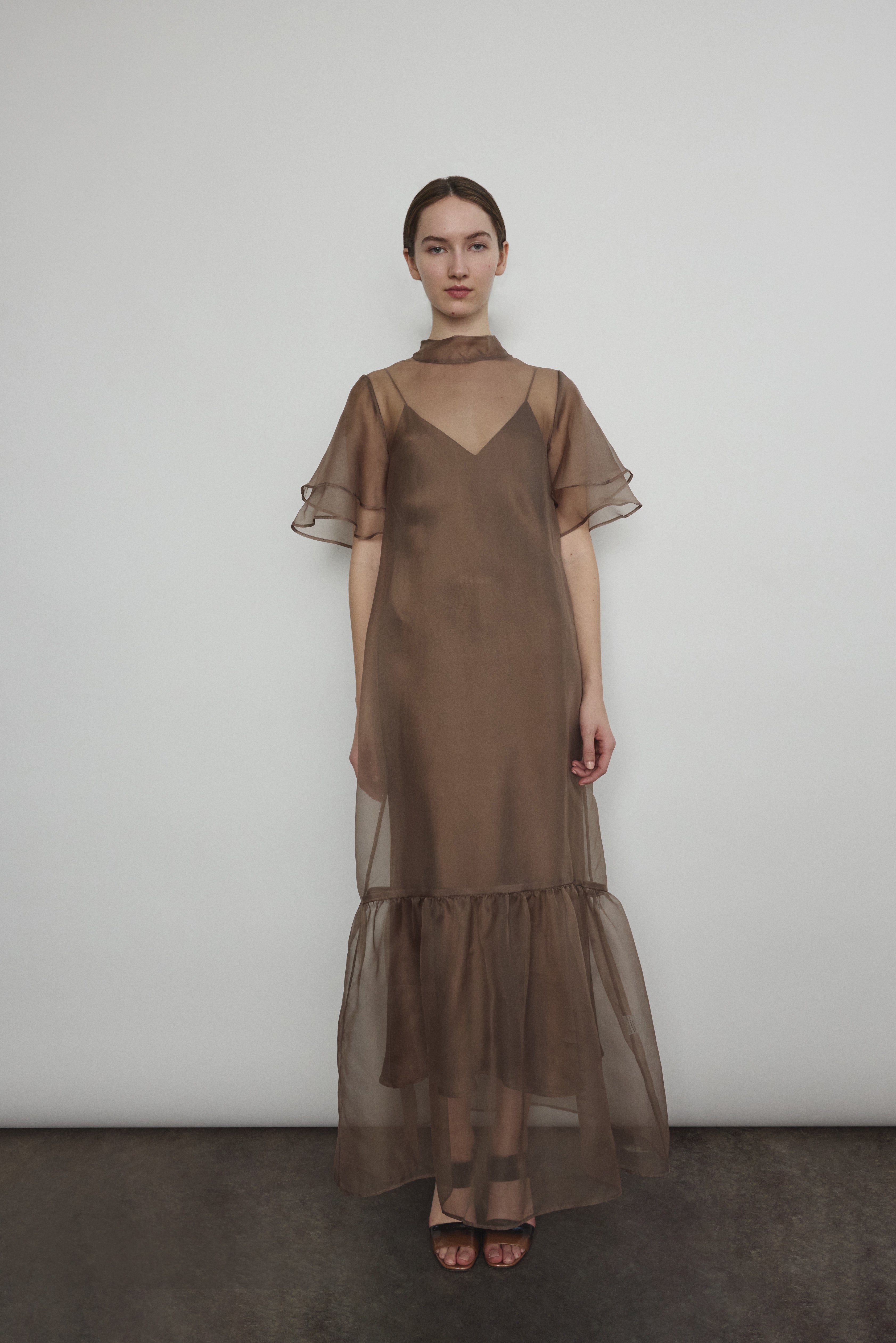 Model in a voluminous mushroom silk organza Barre maxi dress with oversized ruffles and tiered sleeves.