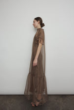 Model in a voluminous mushroom silk organza Barre maxi dress with oversized ruffles and tiered sleeves.