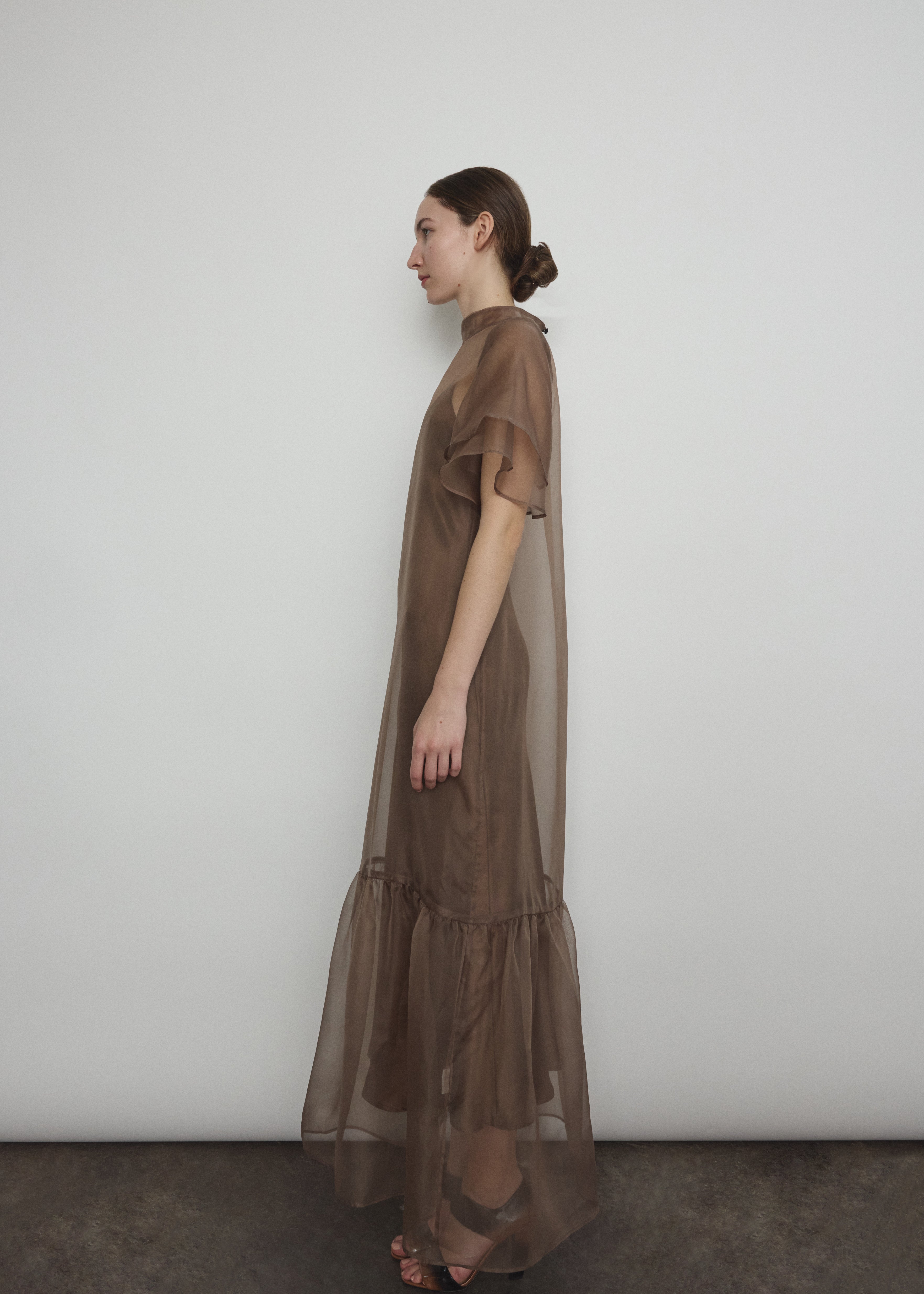 Model in a voluminous mushroom silk organza Barre maxi dress with oversized ruffles and tiered sleeves.