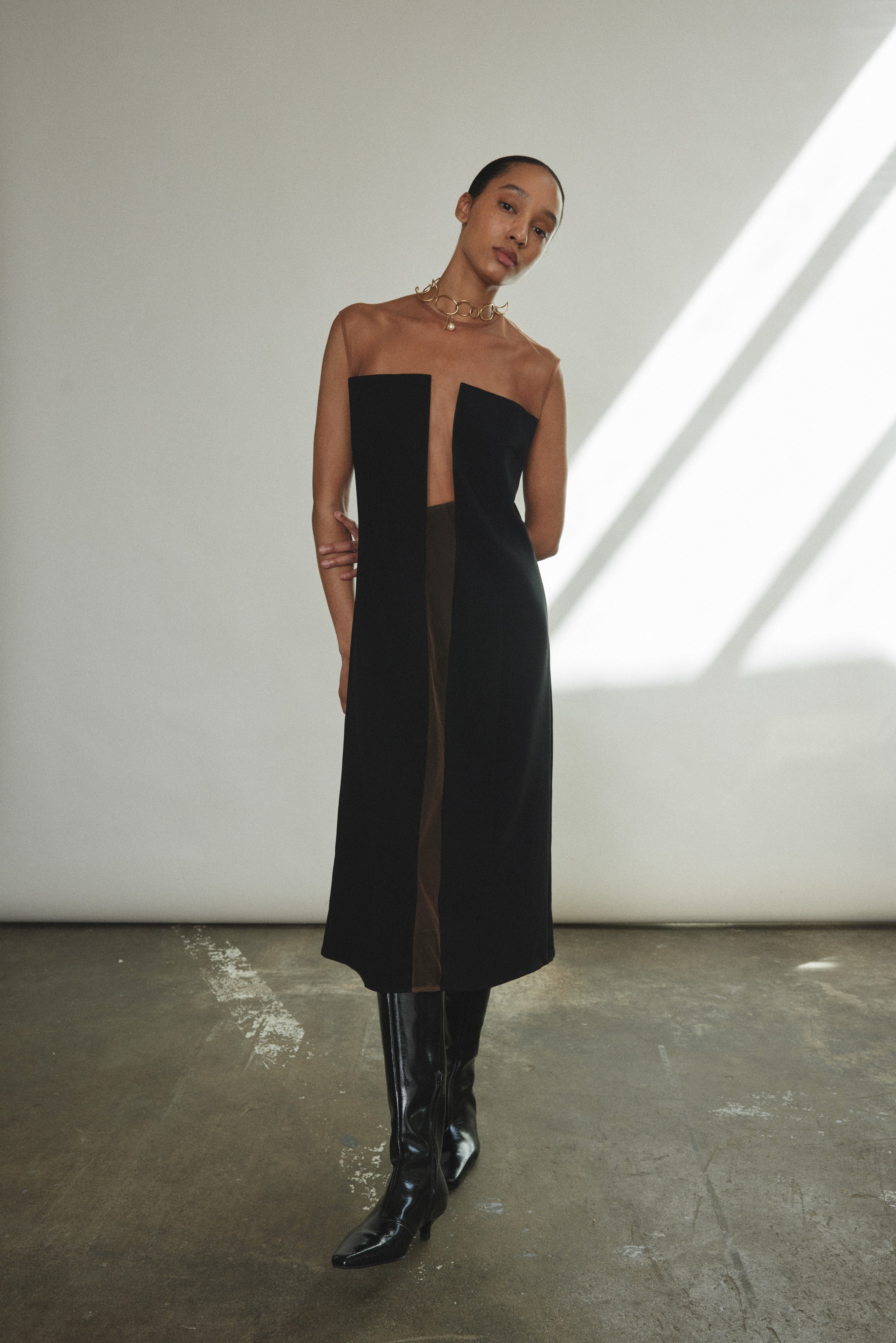 Angled view of the black crepe Kamperett Pirie Shift Dress showing the princess seaming and tulle panel.