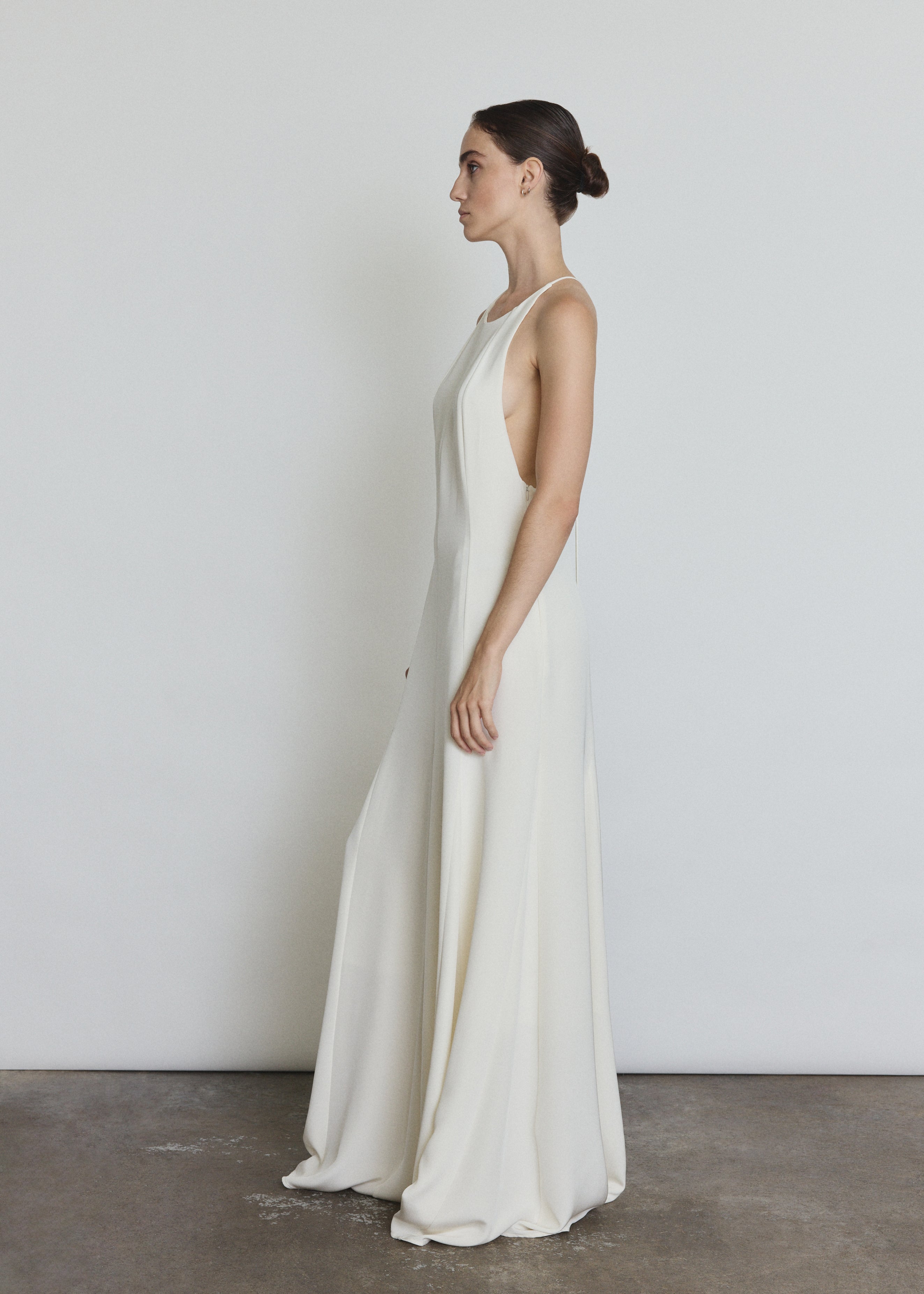 Editorial image of a bride wearing the alabaster Kamperett Ray Gown, a modern bridal halter gown.