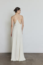 Editorial image of the alabaster Kamperett Ray Gown showing the fluid floor-length silhouette.