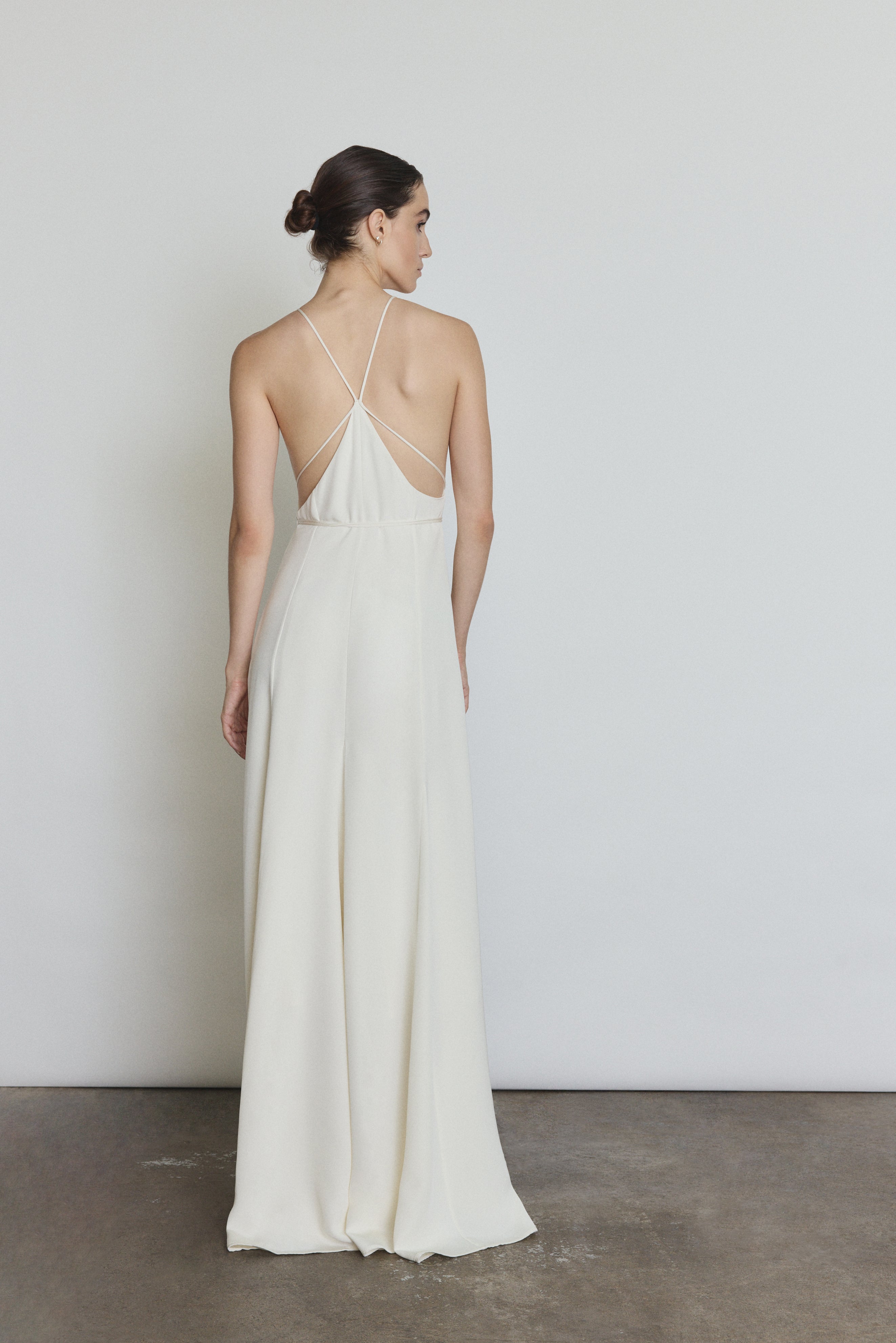 Editorial image of the alabaster Kamperett Ray Gown showing the fluid floor-length silhouette.