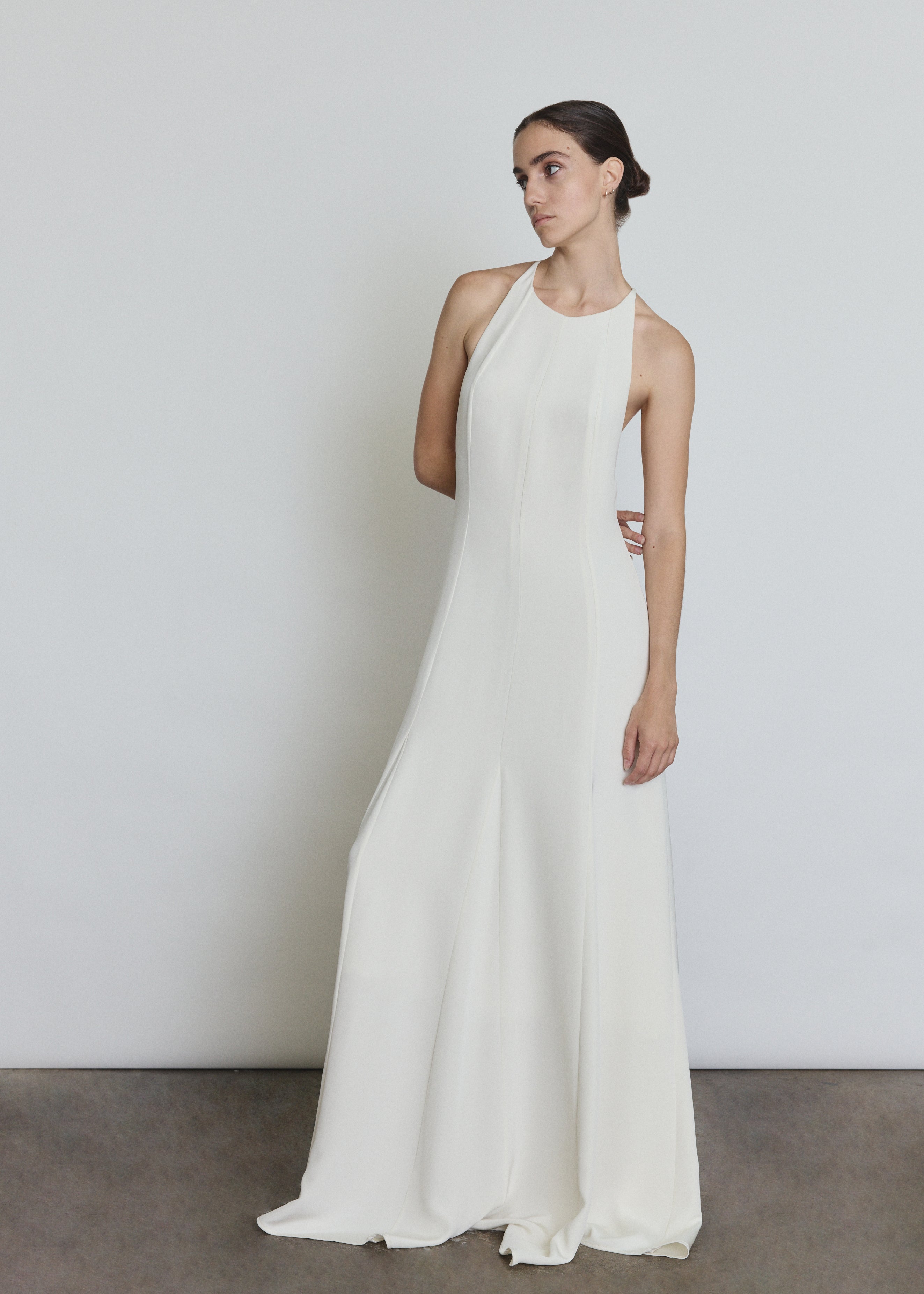 Front view of a bride wearing the alabaster silk crepe Kamperett Ray Gown, a bias-cut halter-neck wedding gown.