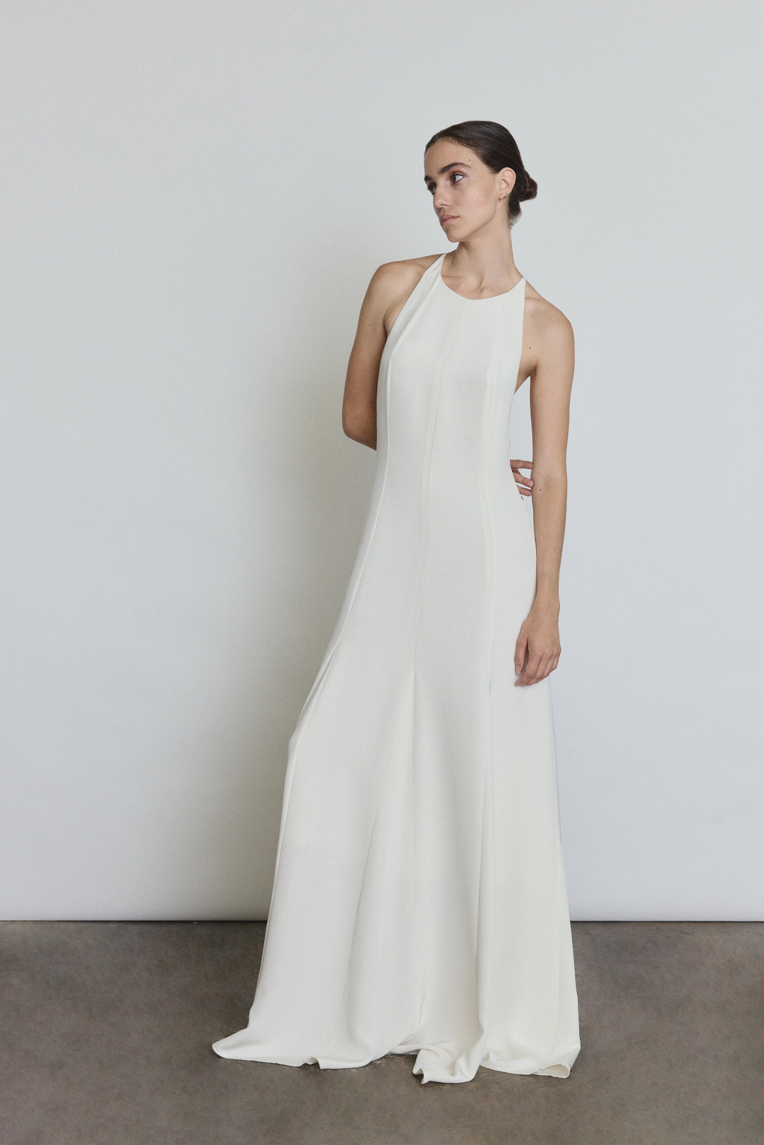 Front view of a bride wearing the alabaster silk crepe Kamperett Ray Gown, a bias-cut halter-neck wedding gown.