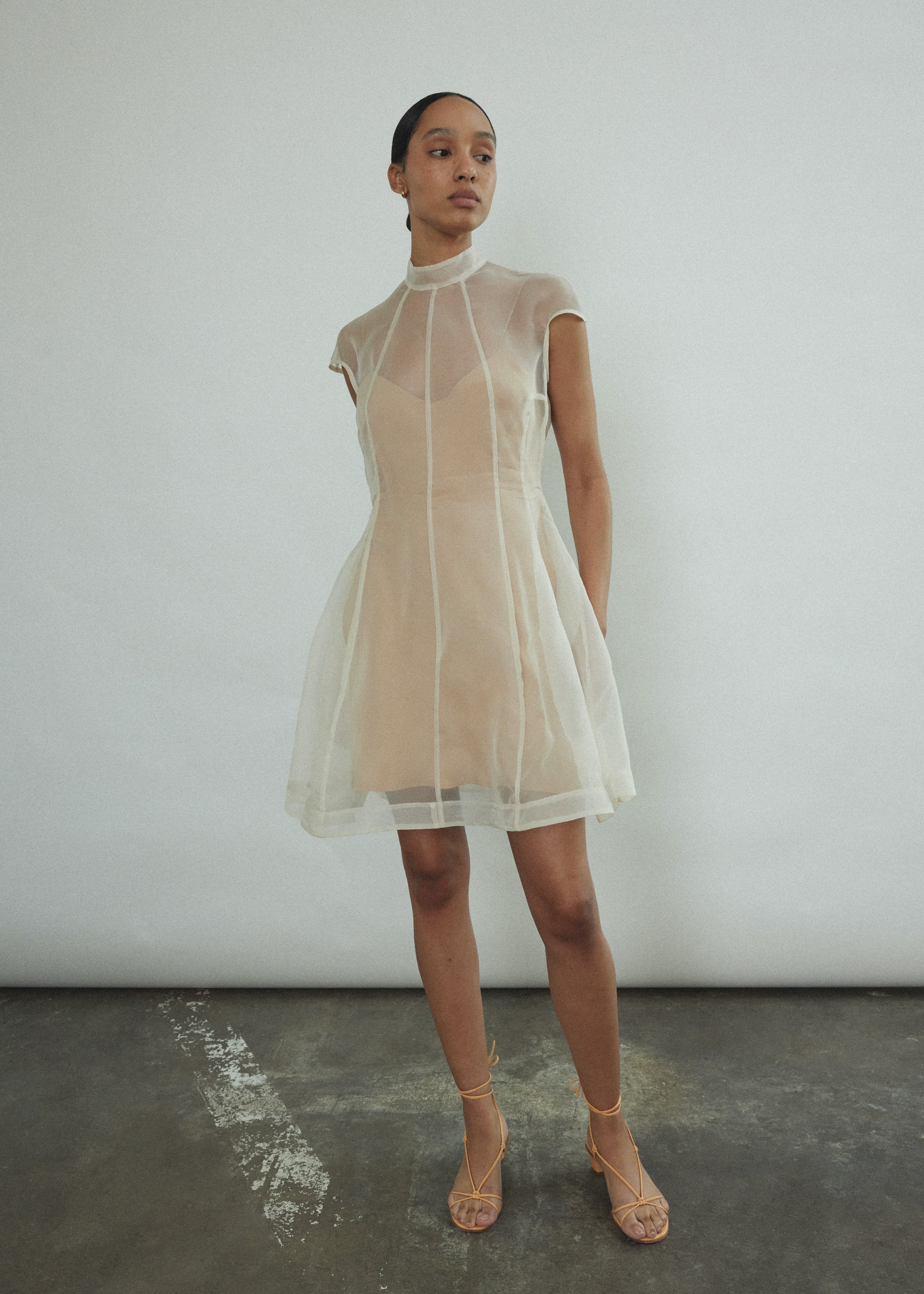 Angled view of the ivory silk organza Kamperett Reine Dress showing the sculpted French seams.