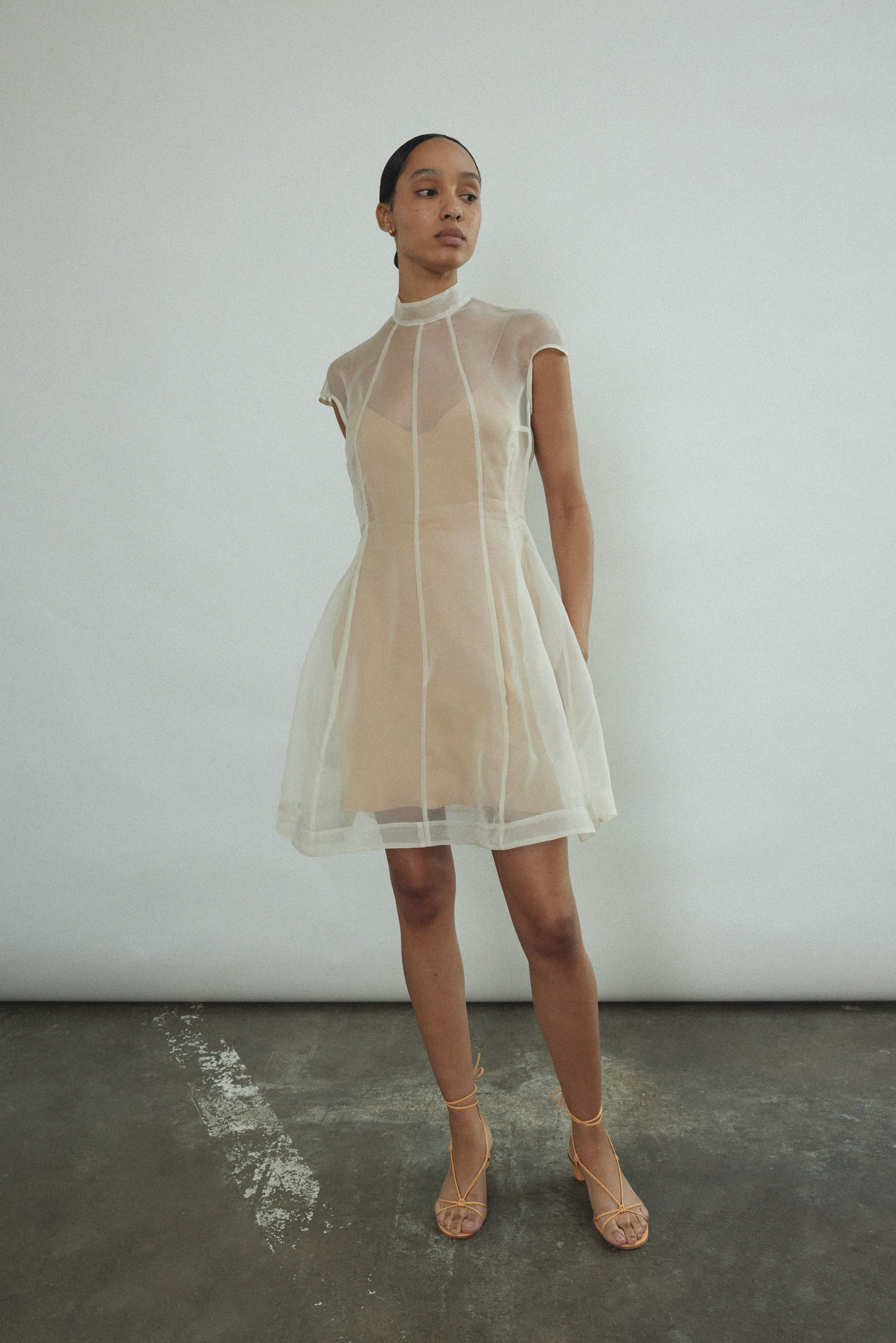 Angled view of the ivory silk organza Kamperett Reine Dress showing the sculpted French seams.