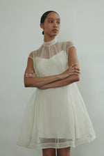 Editorial seated shot of the ivory silk organza Kamperett Reine Dress.