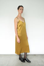 Detail of the dramatic V back on the brass silk charmeuse Kamperett Sade Slip Dress.