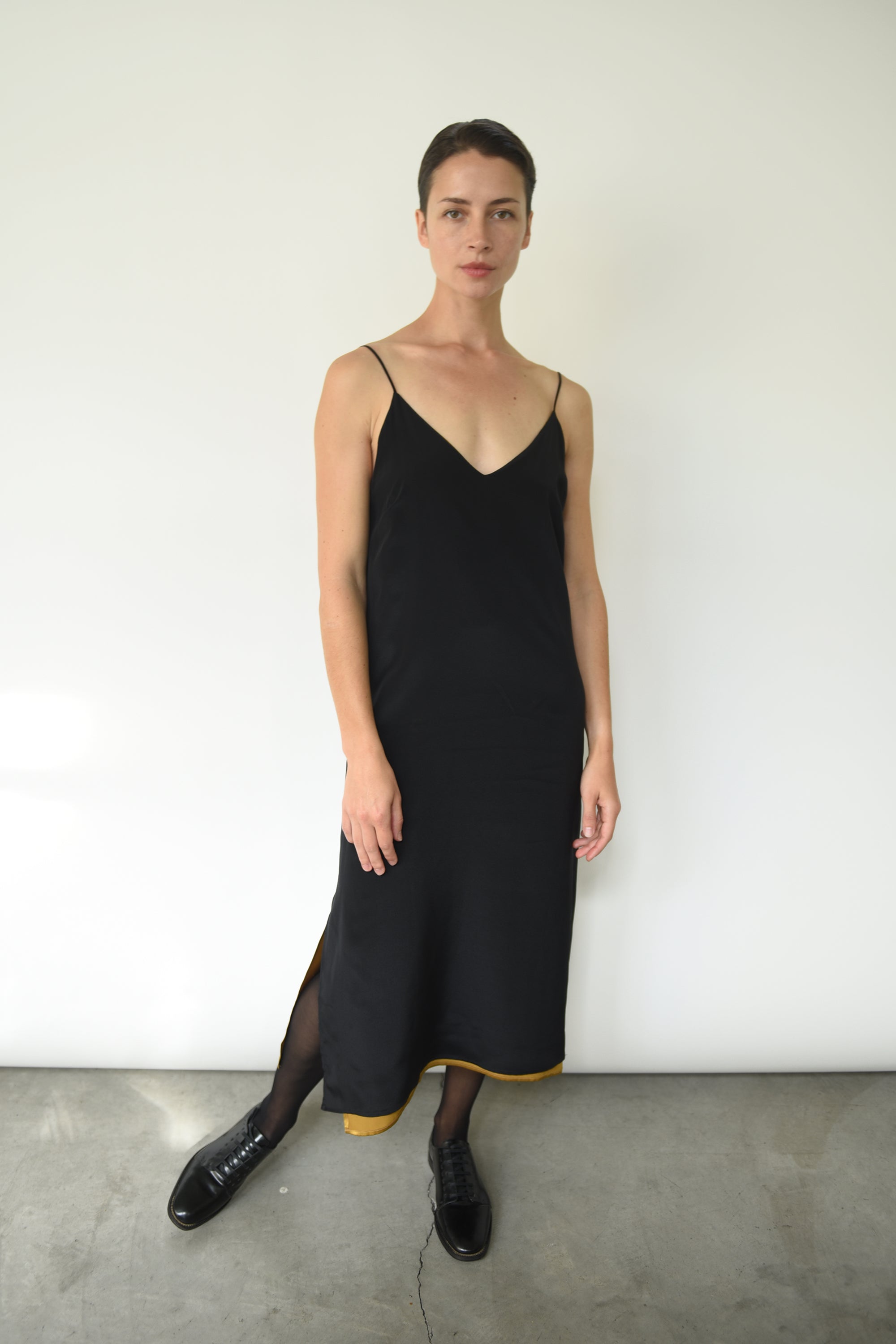 Editorial image of the brass silk charmeuse Kamperett Sade Slip Dress.