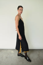 Editorial angled shot of the brass silk charmeuse Kamperett Sade Slip Dress.