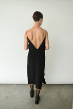 Editorial seated shot of the brass silk charmeuse Kamperett Sade Slip Dress.