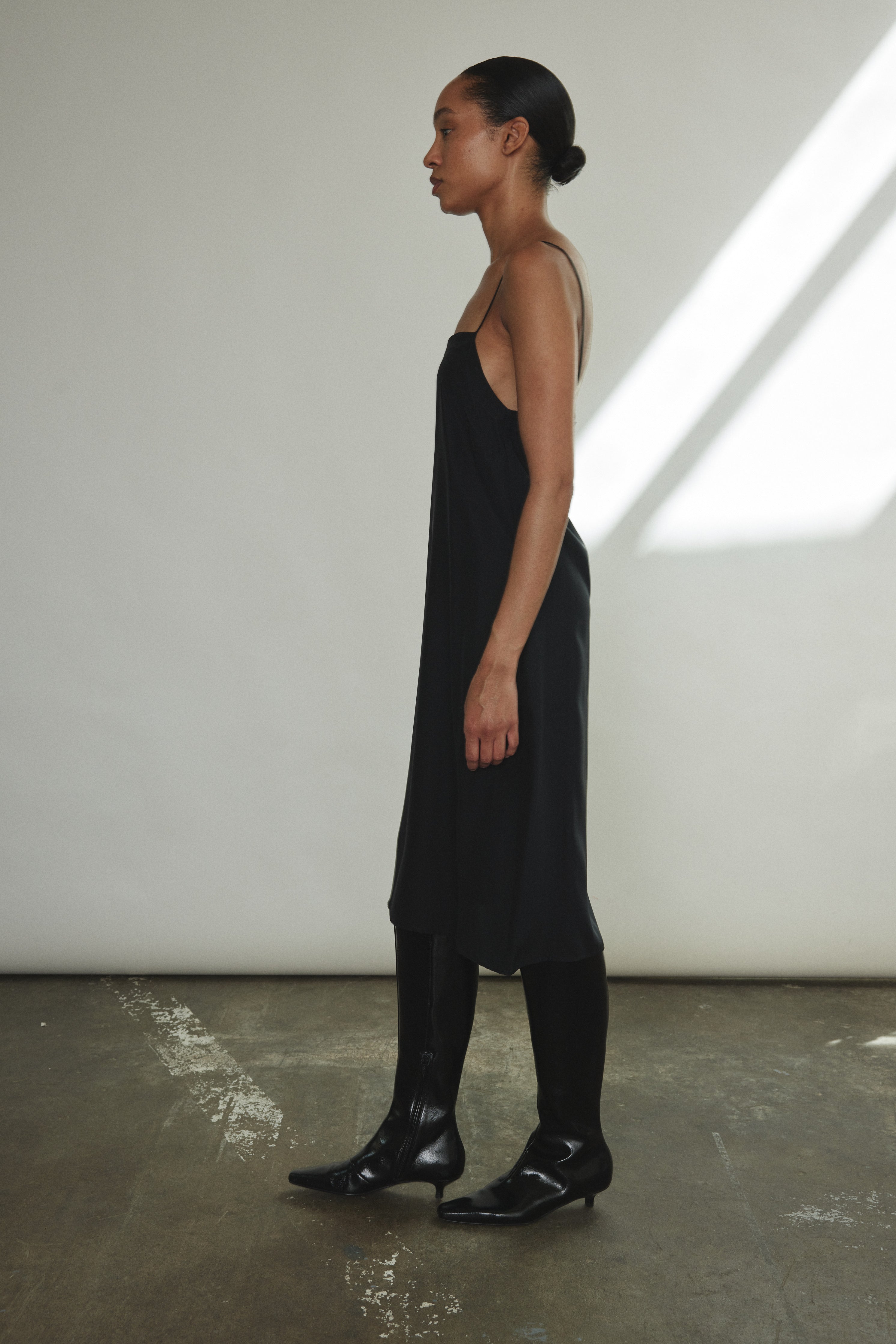Detail view of the black sueded silk charmeuse Kamperett Short Slip with straight-cut neckline.