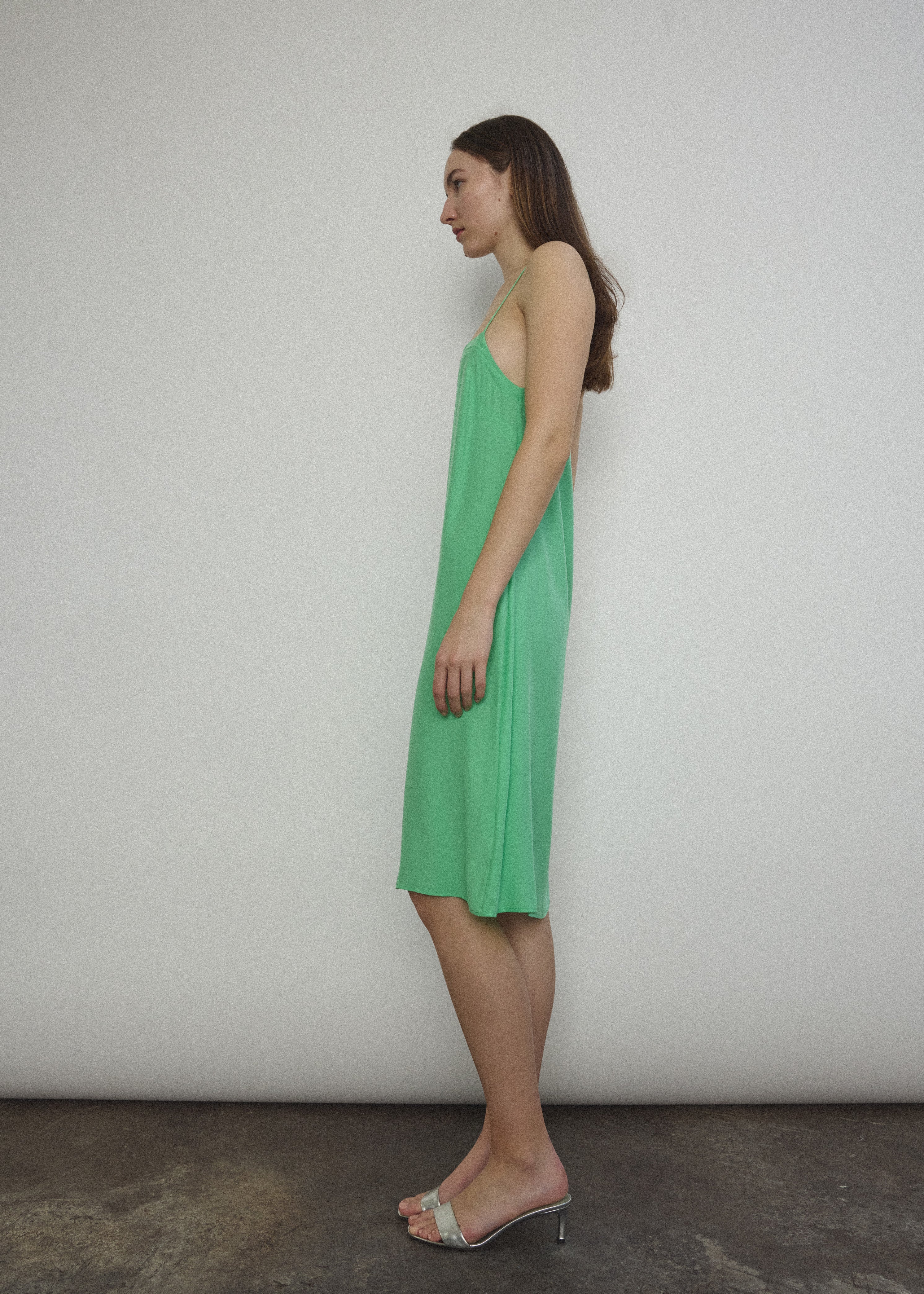 Side view of the celadon silk charmeuse Kamperett Short Slip with straight-cut neckline.