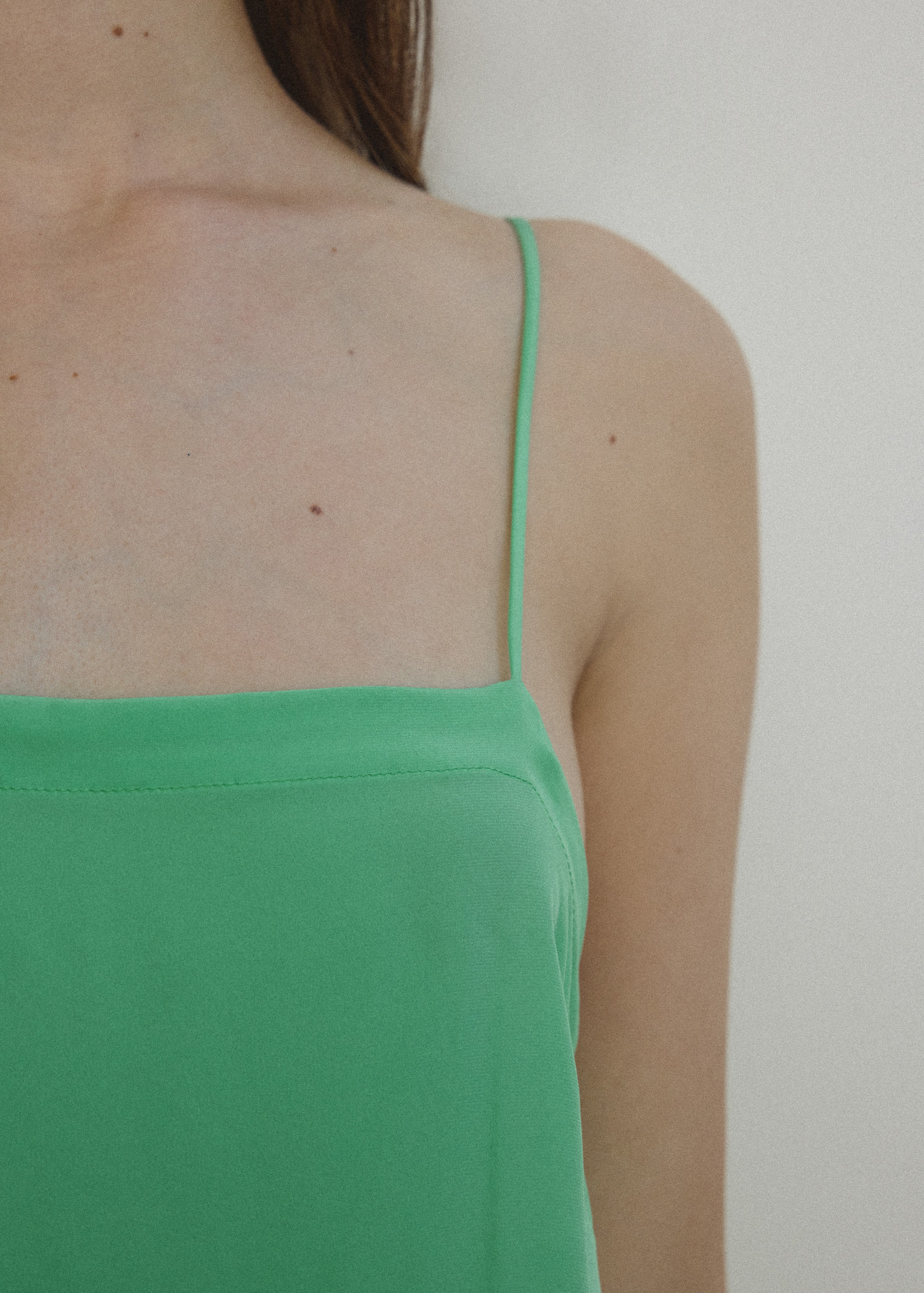 Detail view of the celadon silk charmeuse Kamperett Short Slip showing the fixed spaghetti straps.