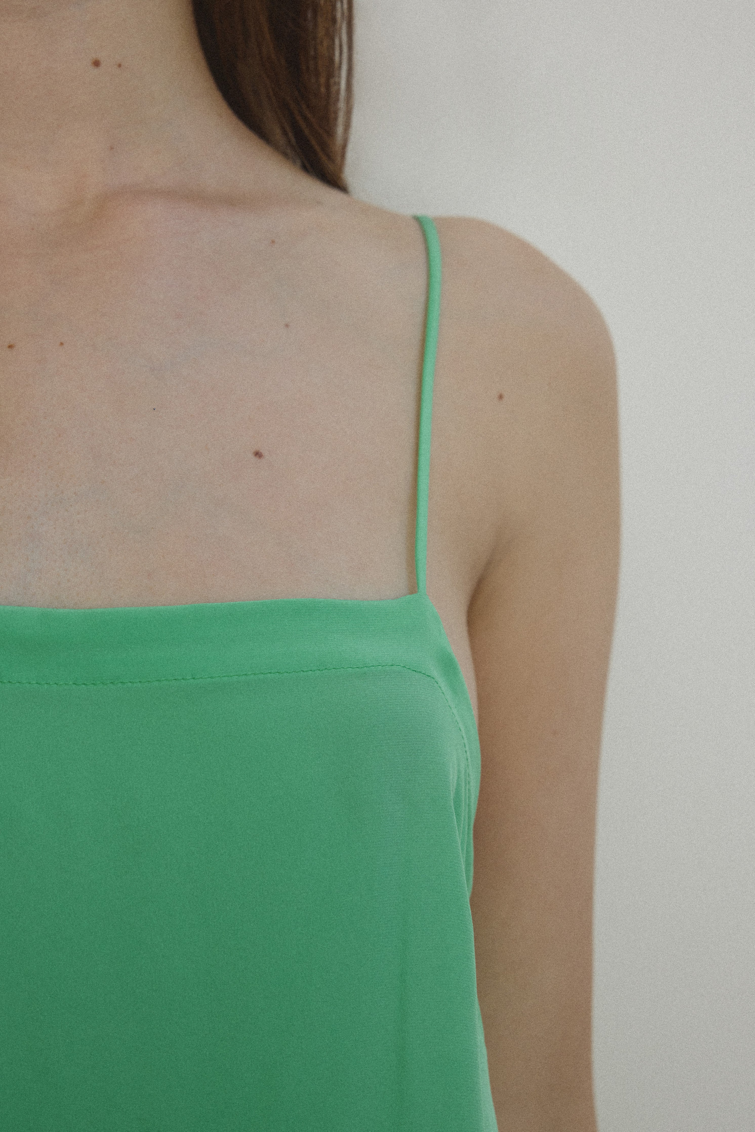 Detail view of the celadon silk charmeuse Kamperett Short Slip showing the fixed spaghetti straps.