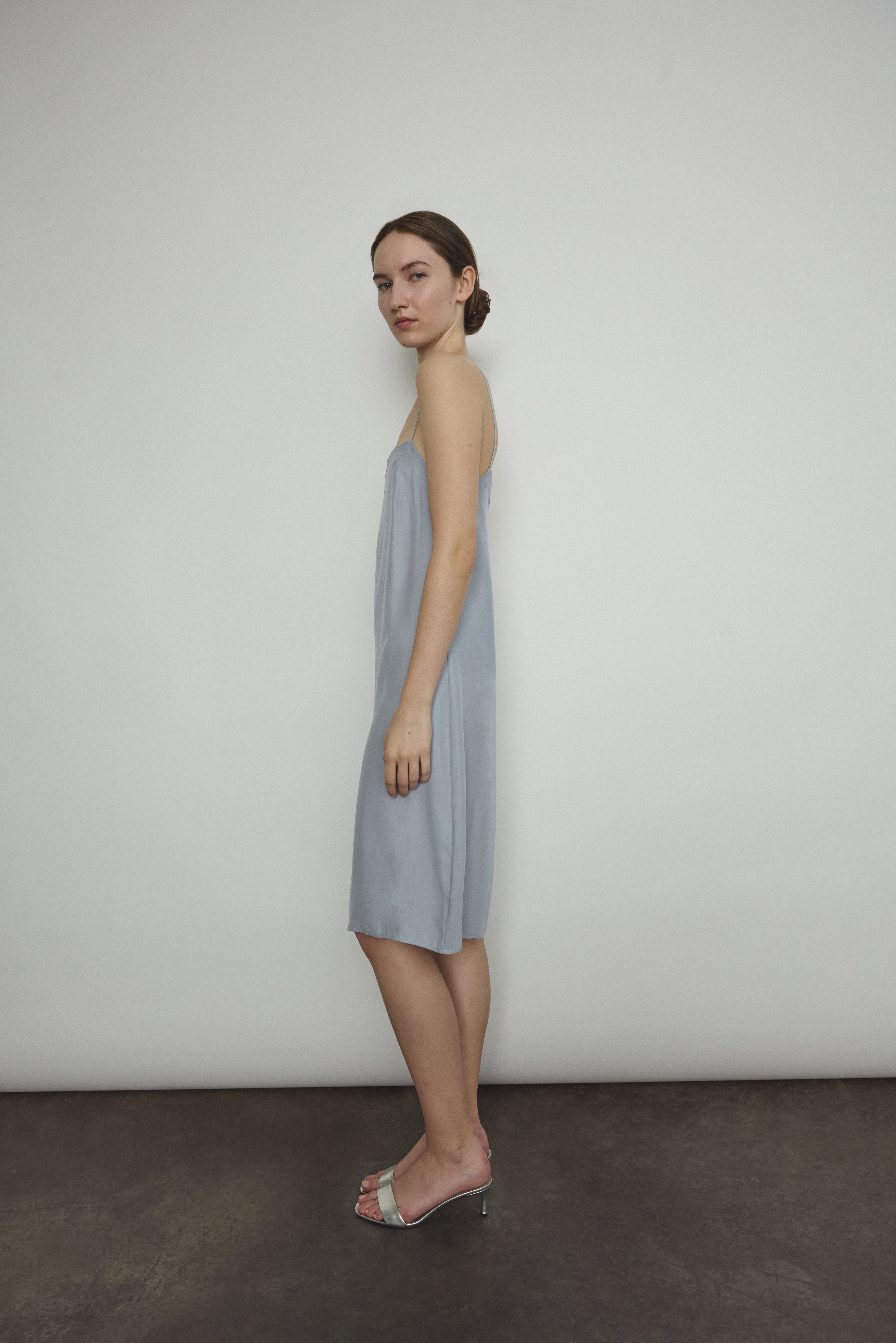 Side view of the powder blue silk charmeuse Kamperett Short Slip with straight-cut neckline.