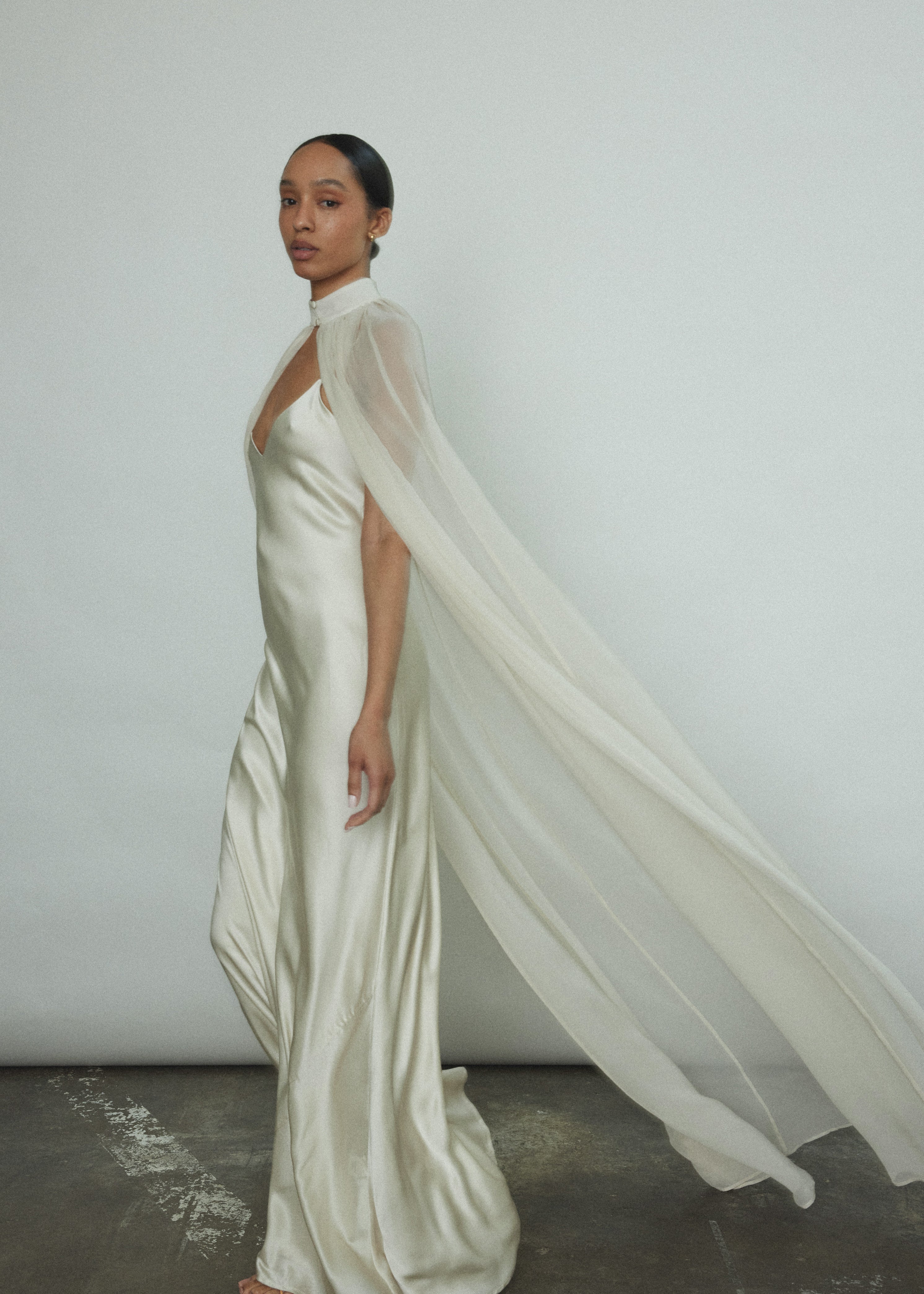 Back motion shot of the ivory silk chiffon Kamperett Choker Cape showing the sweeping veil drape.