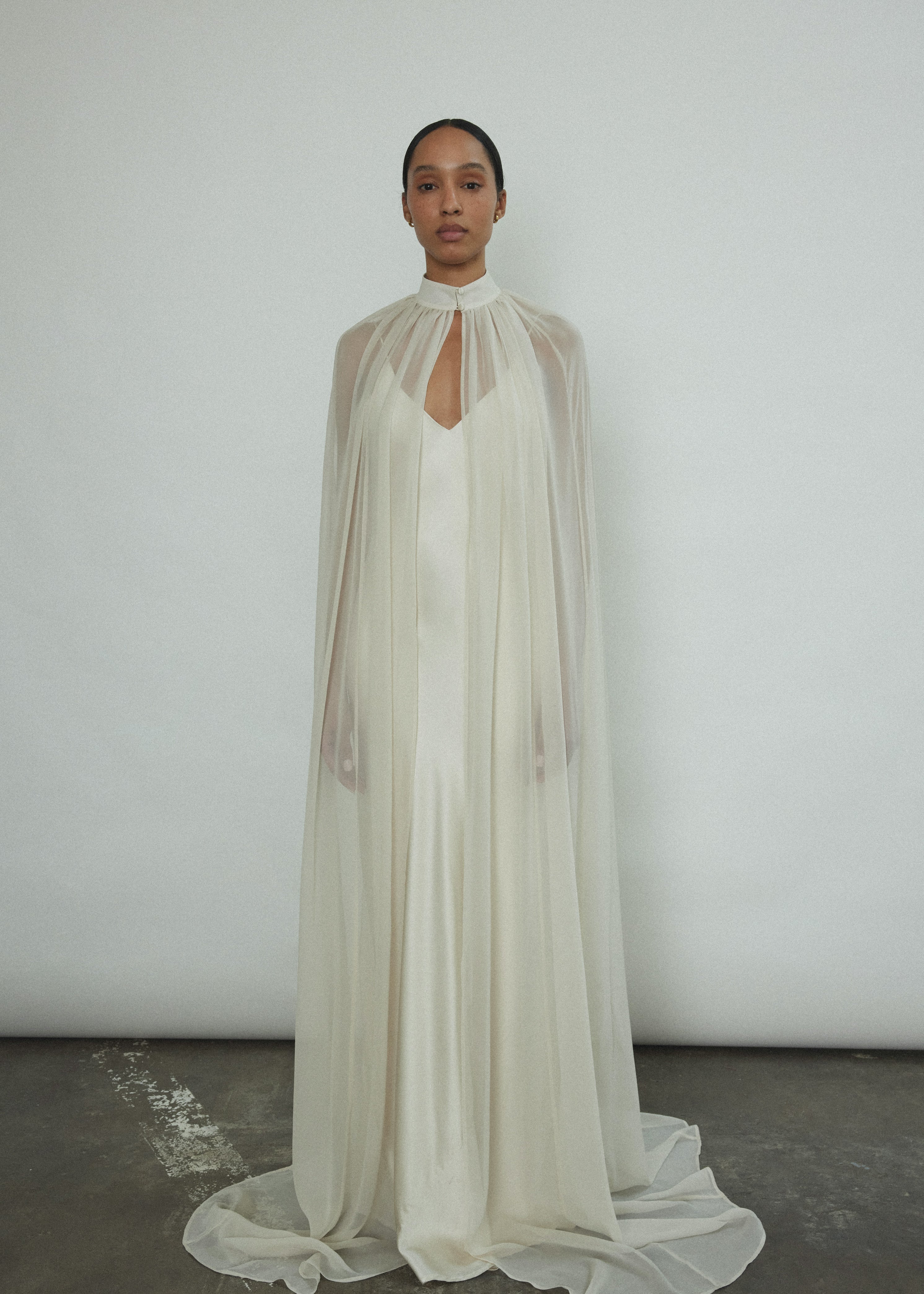 Front view of a bride wearing the ivory Kamperett Silk Chiffon Choker Cape, a modern alternative to the traditional bridal veil.