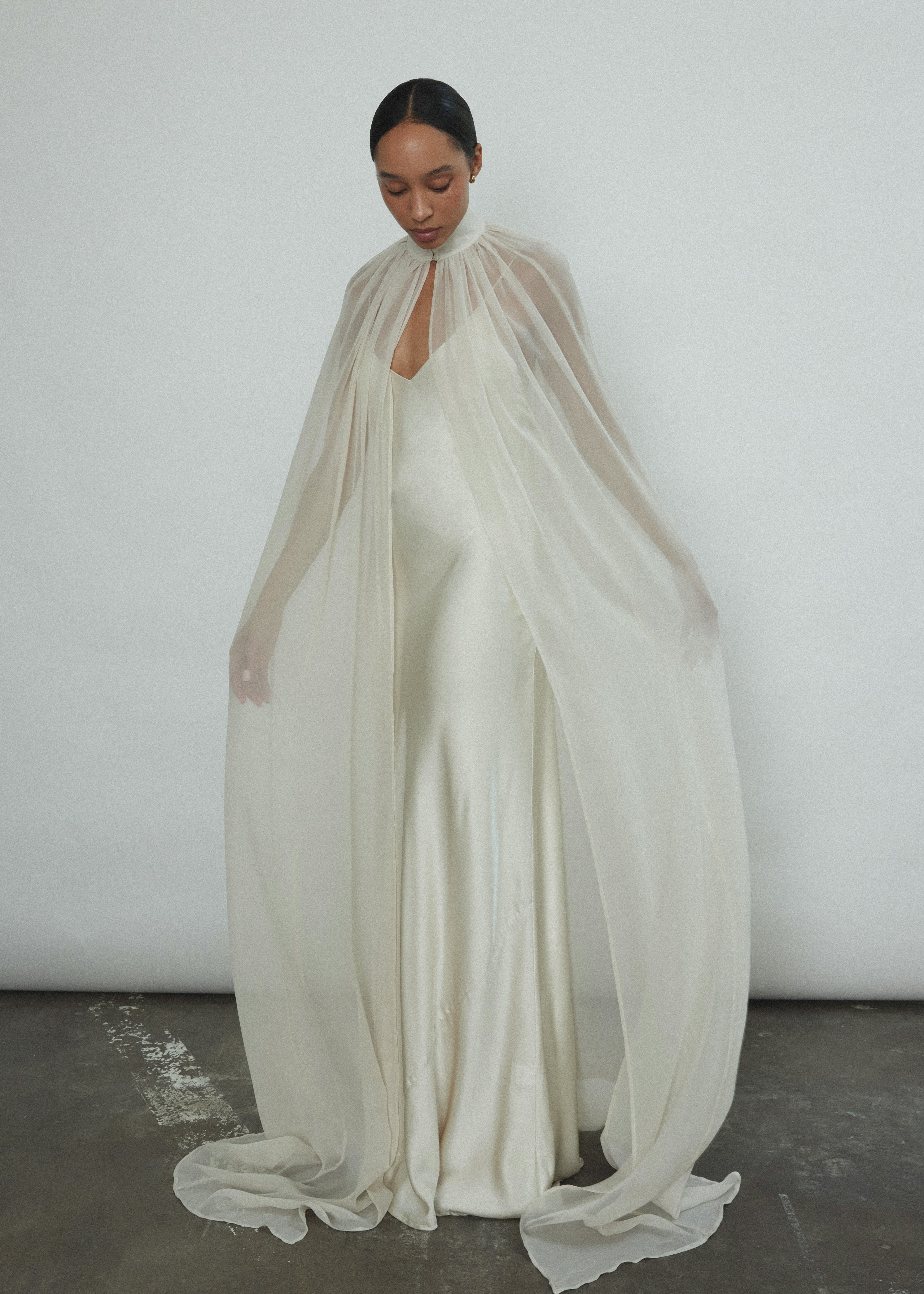 Side view of the ivory silk chiffon Kamperett Choker Cape with self-button collar at front neck.