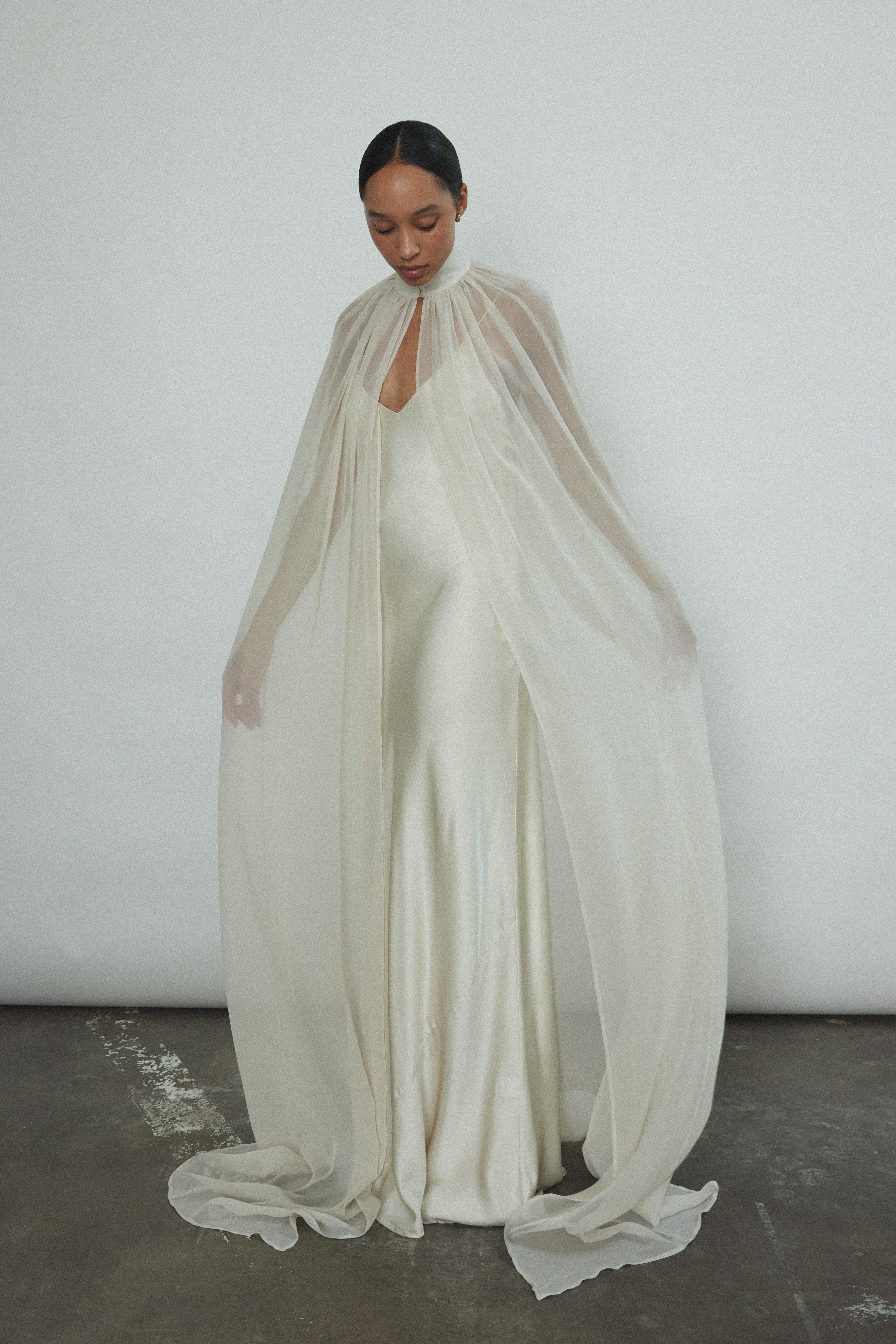 Side view of the ivory silk chiffon Kamperett Choker Cape with self-button collar at front neck.