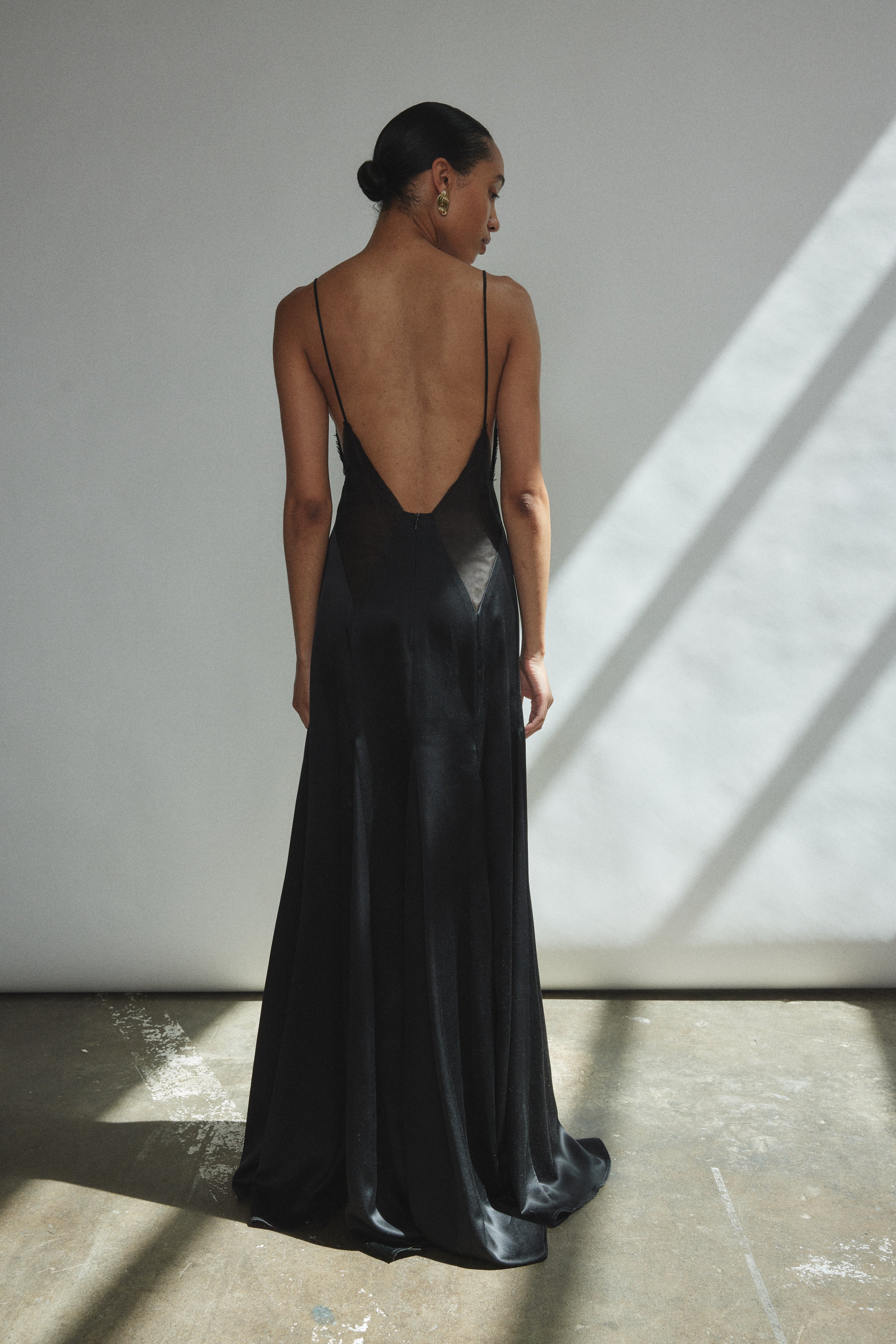 Detail of the corded spaghetti straps on the black silk charmeuse Kamperett Simone Slip Dress.