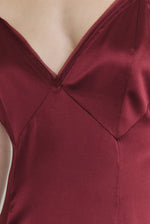 Editorial image of a model wearing the bordeaux Kamperett Simone Slip Dress, a modern deco-inspired occasion gown.