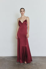 Front view of a model wearing the bordeaux silk charmeuse Kamperett Simone Slip Dress, a deco-inspired slip with V neck and corded straps.