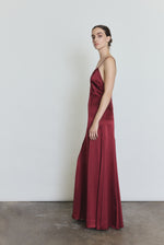 Side view of the bordeaux silk charmeuse Kamperett Simone Slip Dress showing the multi-godet hemline.