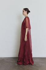Model wearing the bordeaux Kamperett Simone Slip Dress layered under the Thea Sheath Dress in Bordeaux, styled with motion.