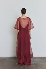 Editorial image of the bordeaux Kamperett Simone Slip Dress layered under the Thea Sheath Dress in Bordeaux.