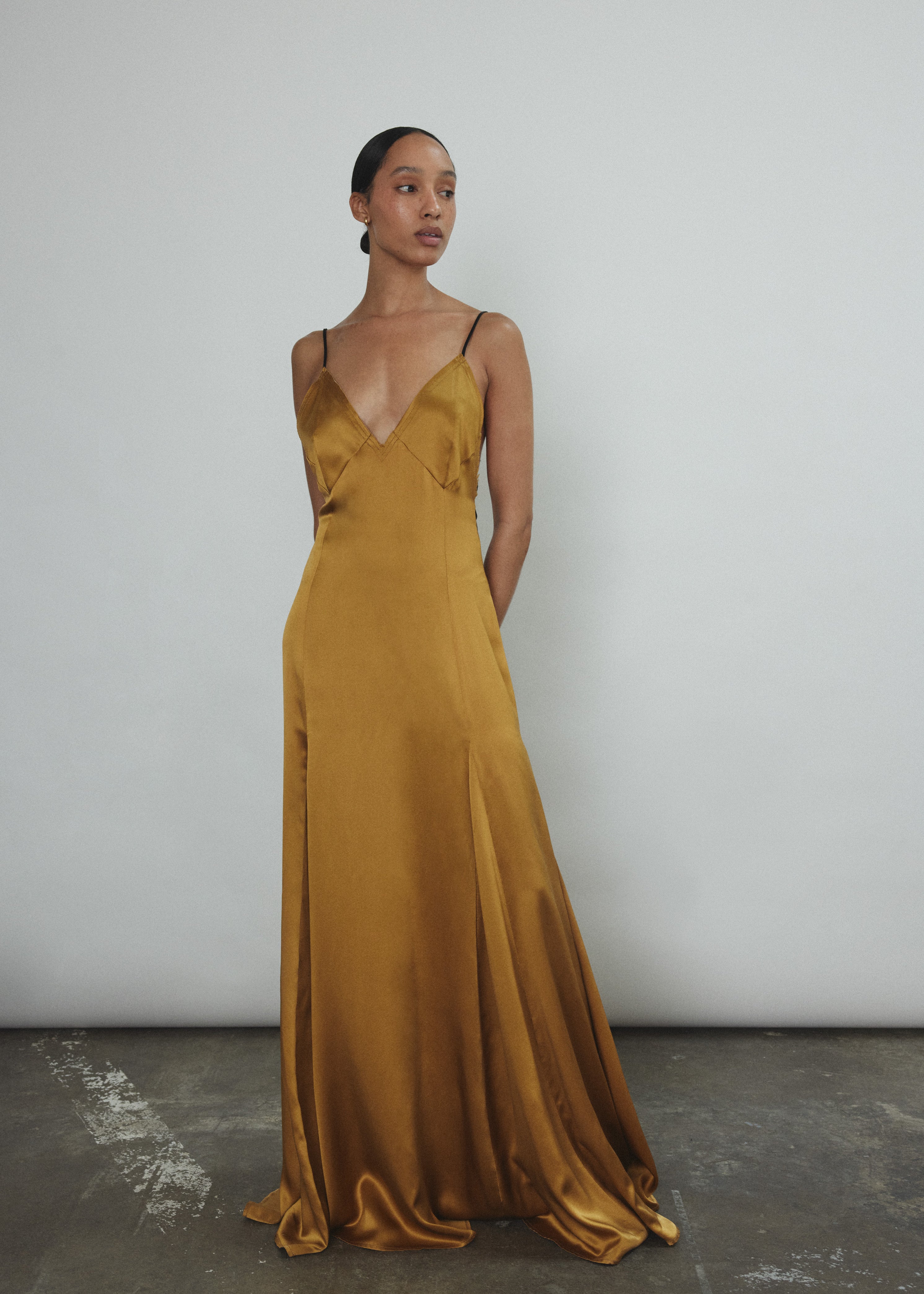 Angled view of the brass silk charmeuse Kamperett Simone Slip Dress.