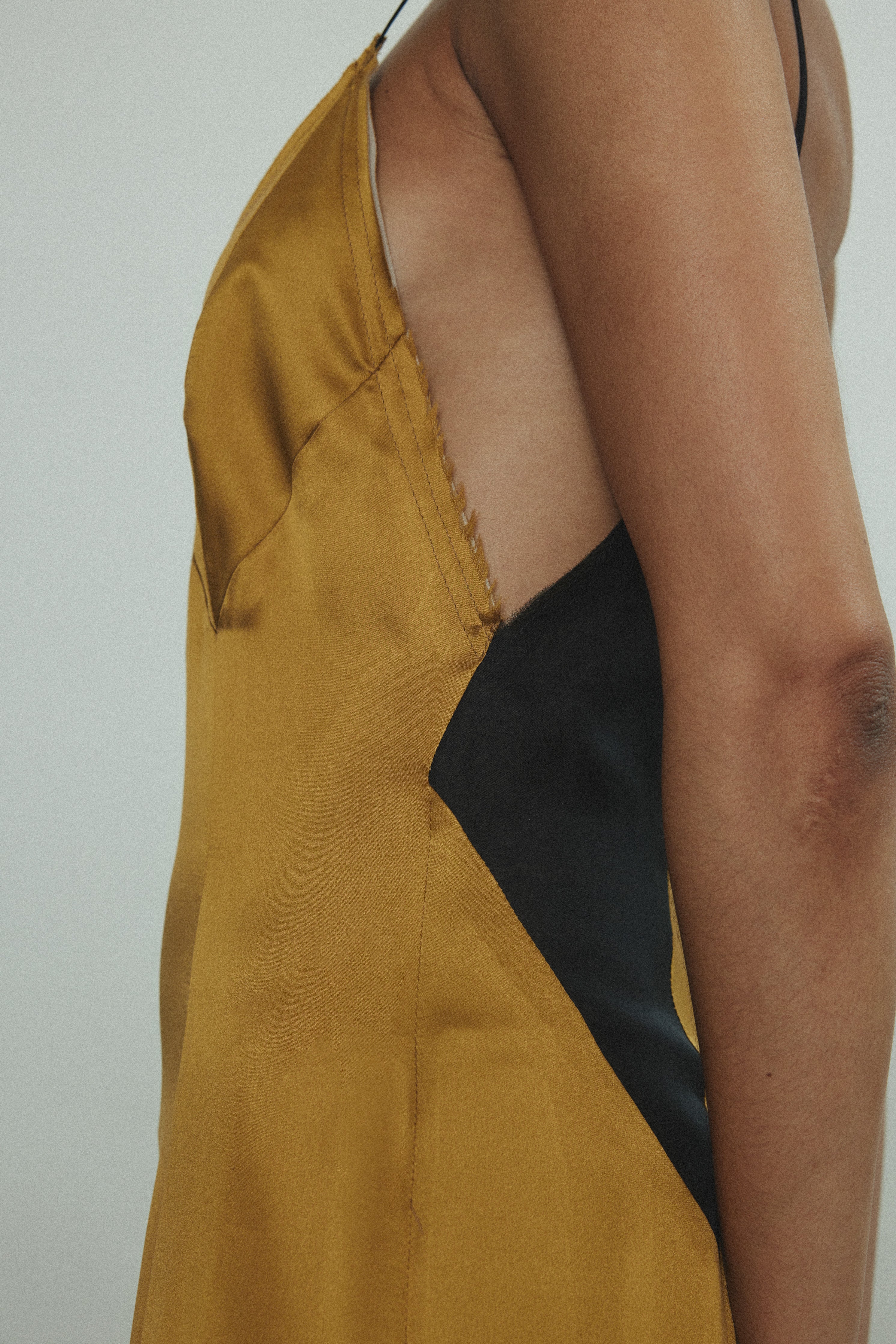 Back view of the brass silk charmeuse Kamperett Simone Slip Dress with invisible zip closure.
