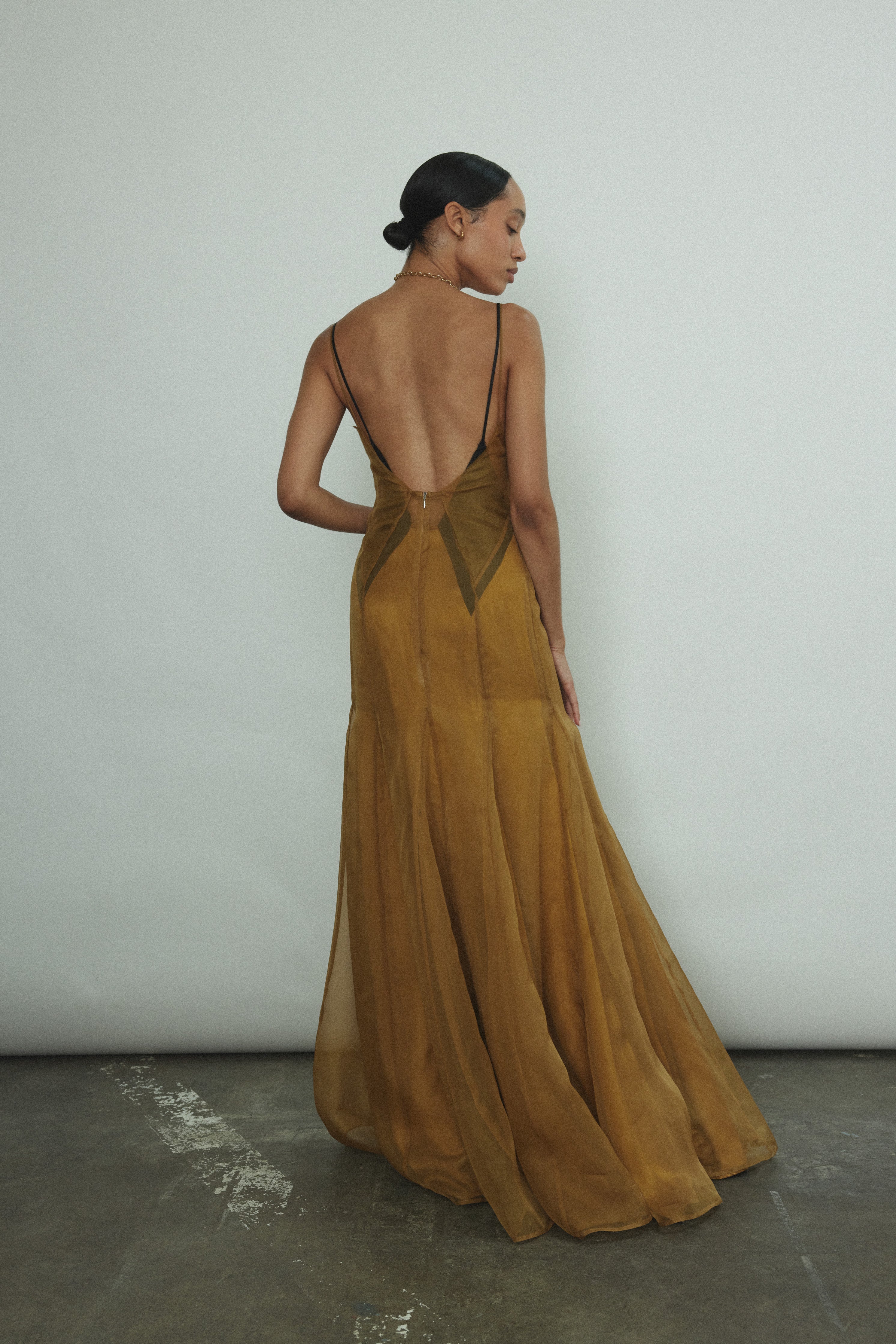 Editorial image of the brass silk charmeuse Kamperett Simone Slip Dress.
