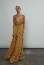 Front view of the brass silk charmeuse Kamperett Simone Slip Dress with corded spaghetti straps.