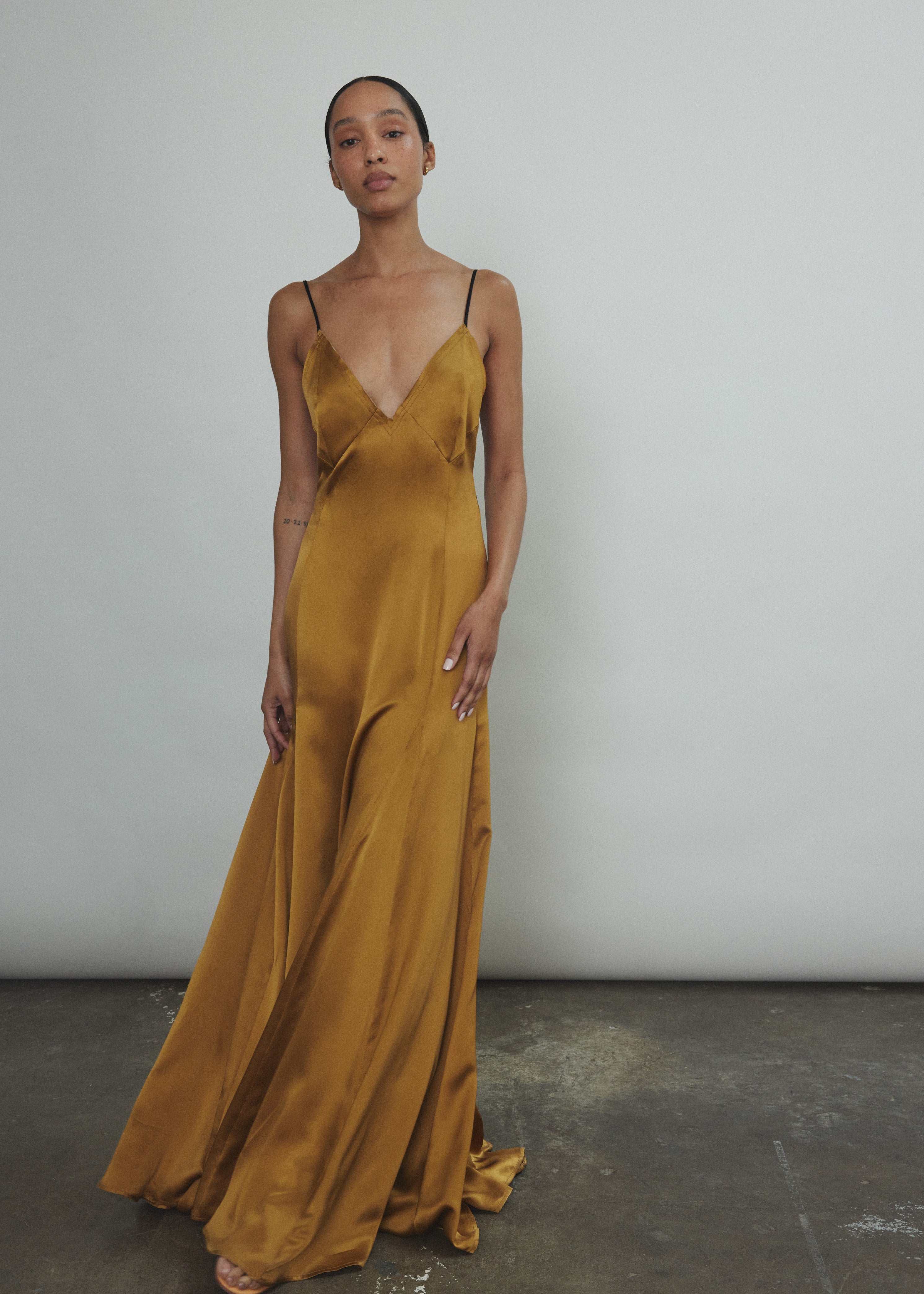 Front view of the brass silk charmeuse Kamperett Simone Slip Dress with corded spaghetti straps.