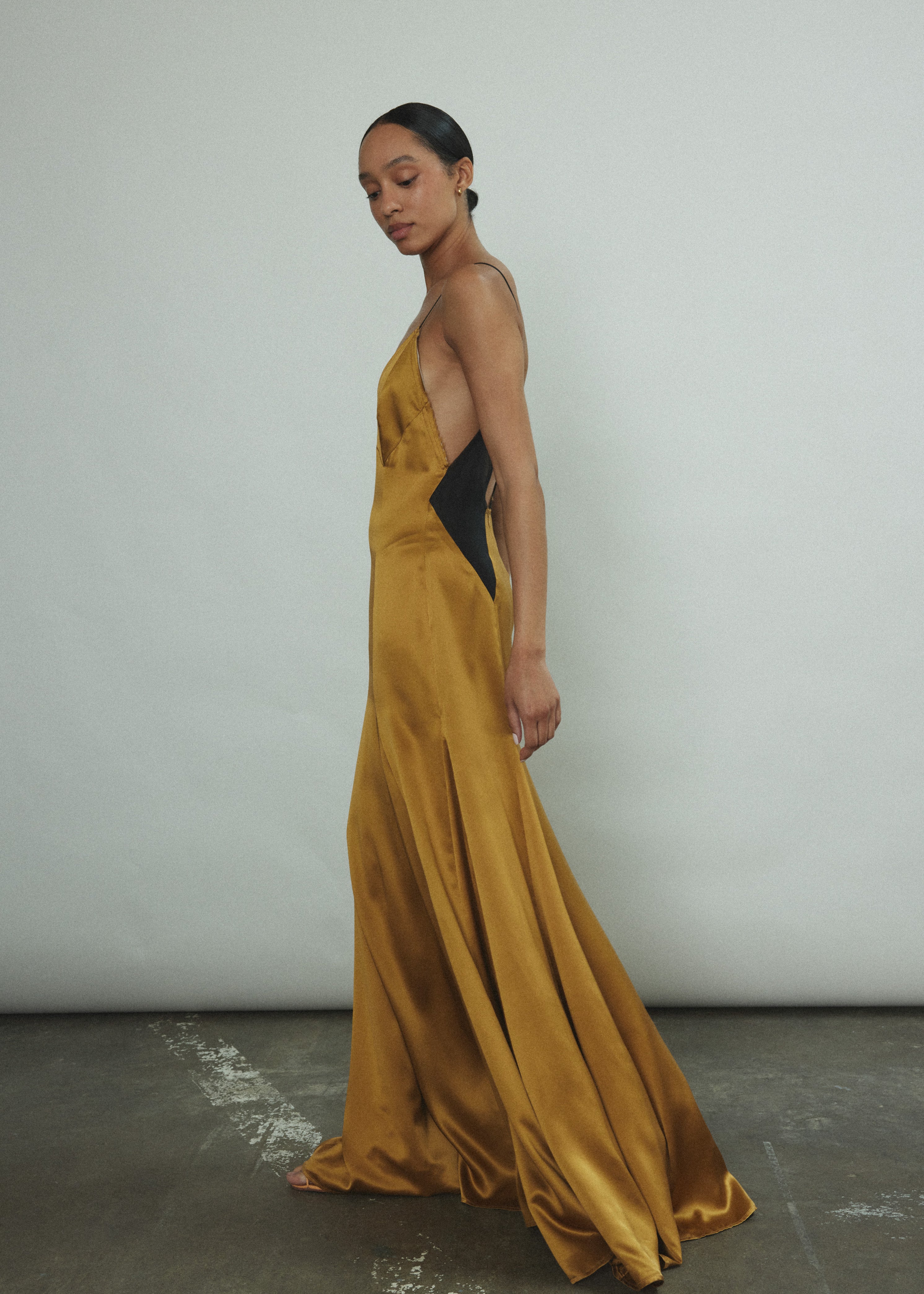 Detail of the sheer diamond-shaped panels on the brass silk charmeuse Kamperett Simone Slip Dress.