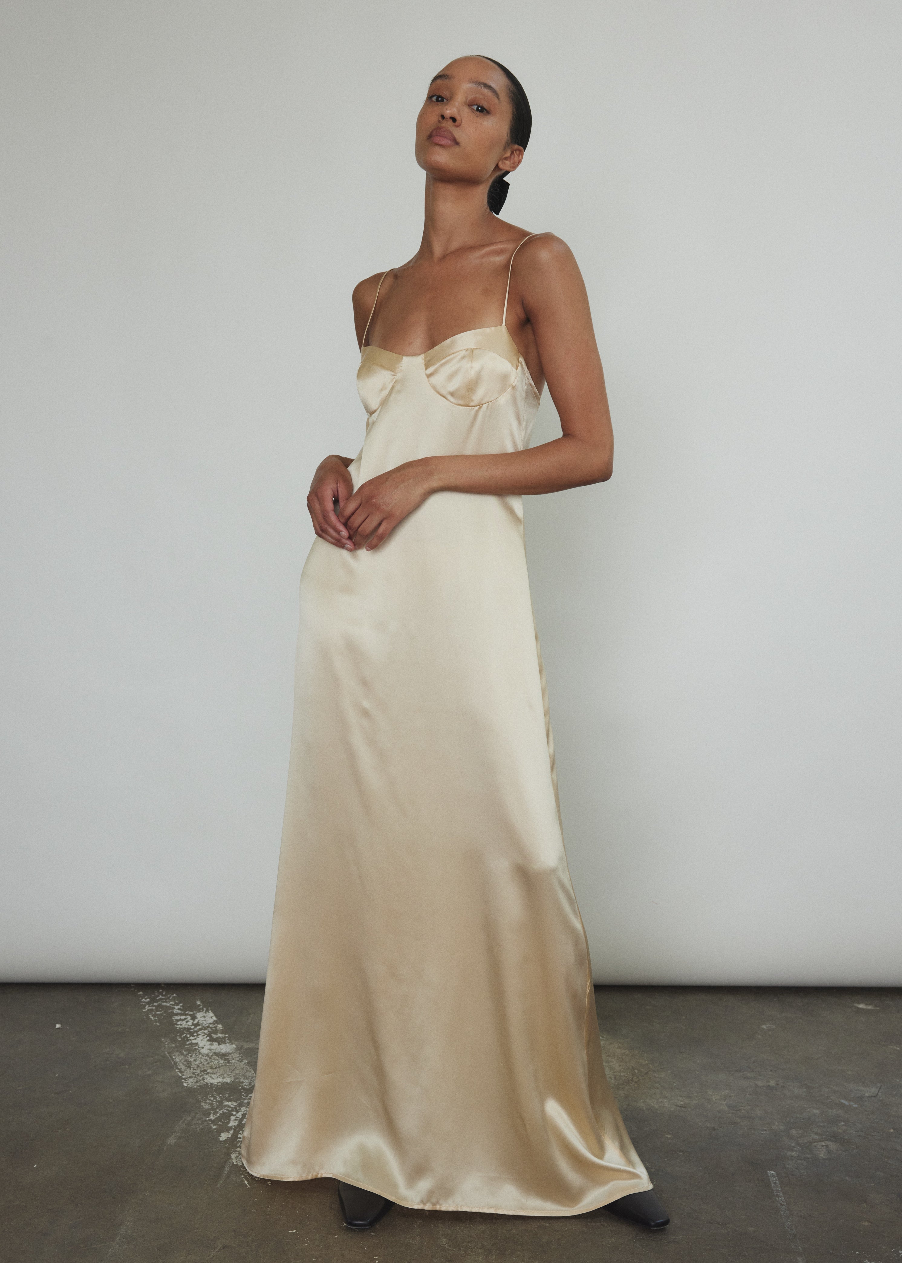 Angled view of the champagne silk charmeuse Kamperett Sloan Slip with corded straps.