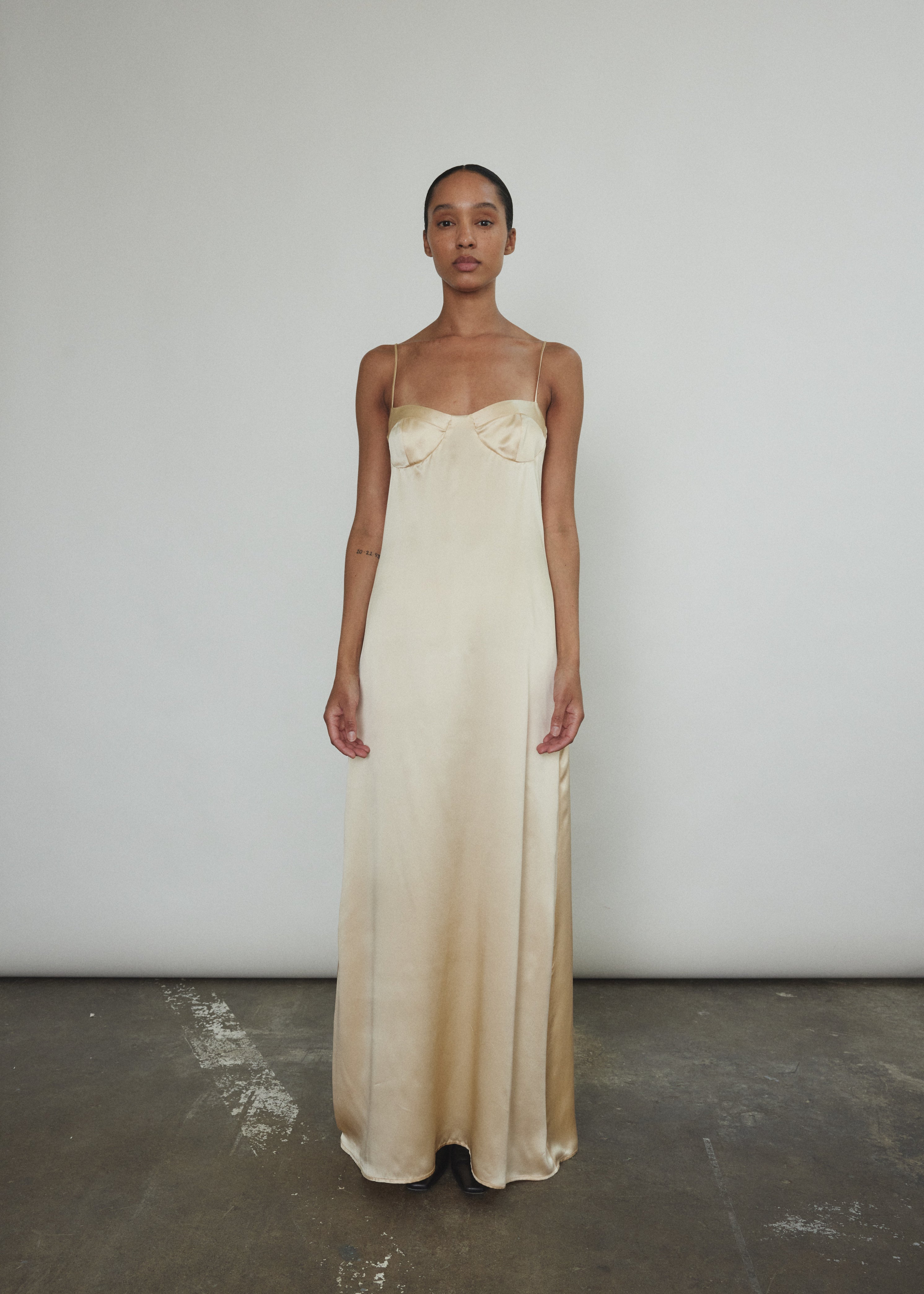 Side view of the champagne silk charmeuse Kamperett Sloan Slip showing the structured three-part cup detail.
