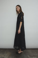 Editorial image of the black French lace Kamperett Thea Lace Sheath Dress.