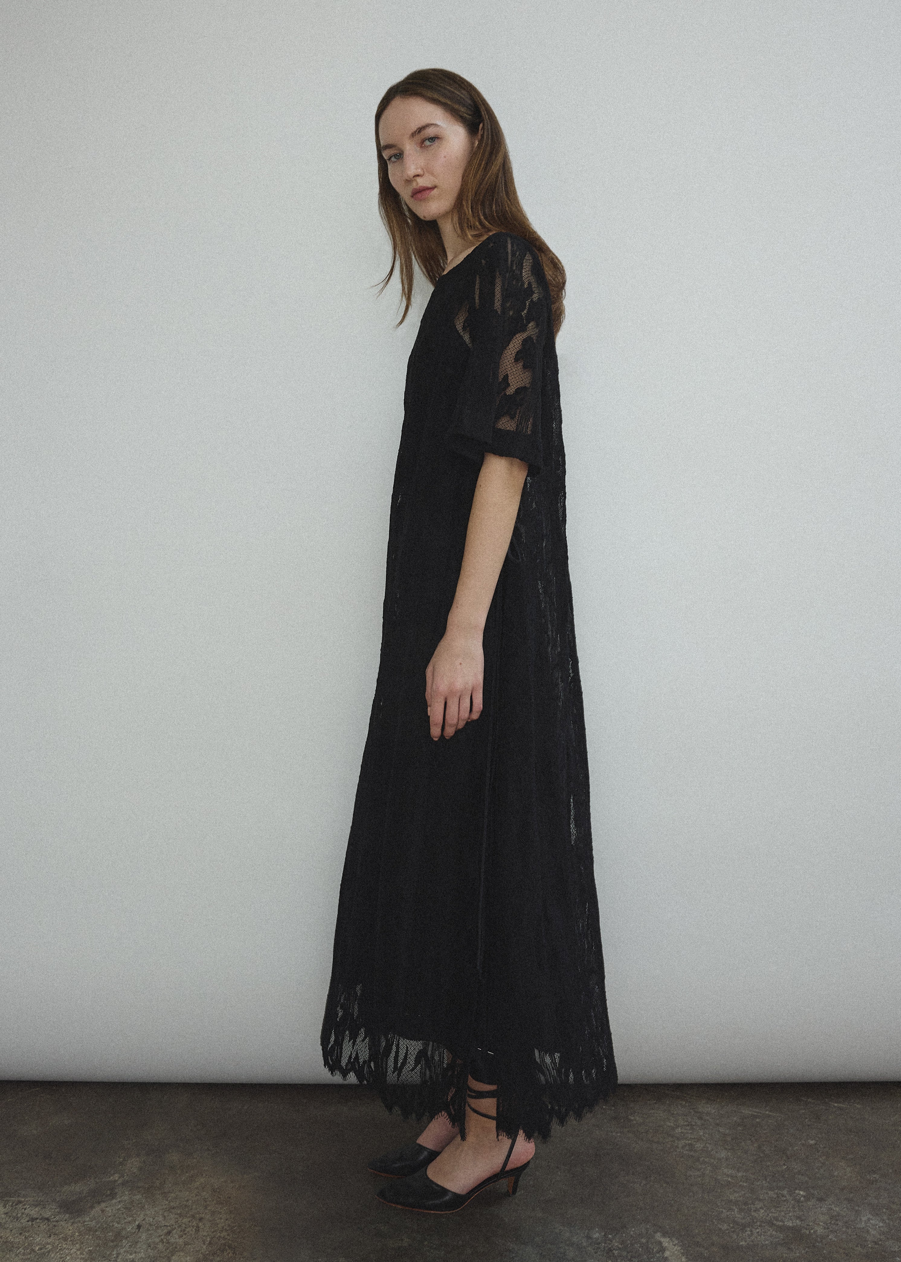 Editorial image of the black French lace Kamperett Thea Lace Sheath Dress.