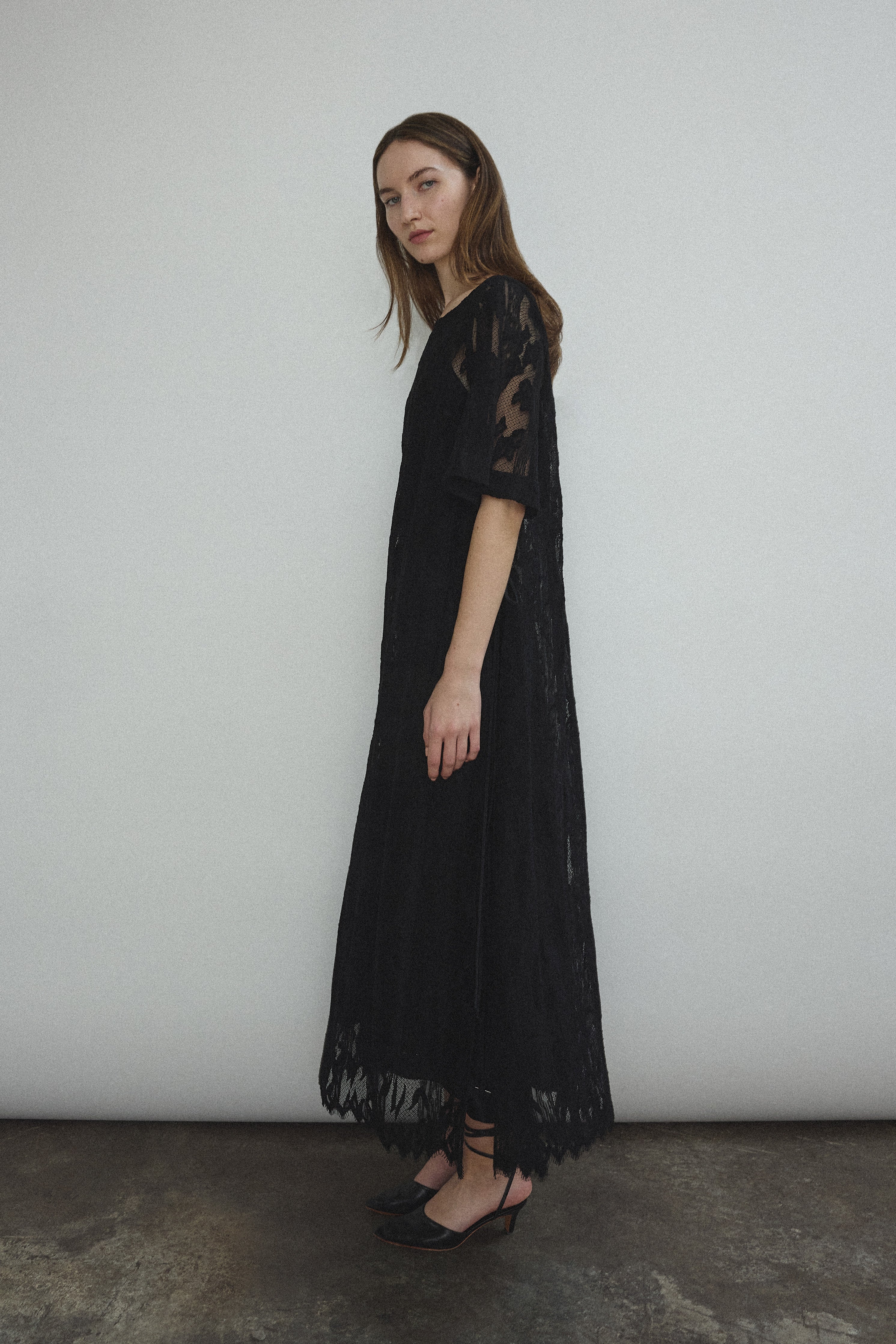Editorial image of the black French lace Kamperett Thea Lace Sheath Dress.